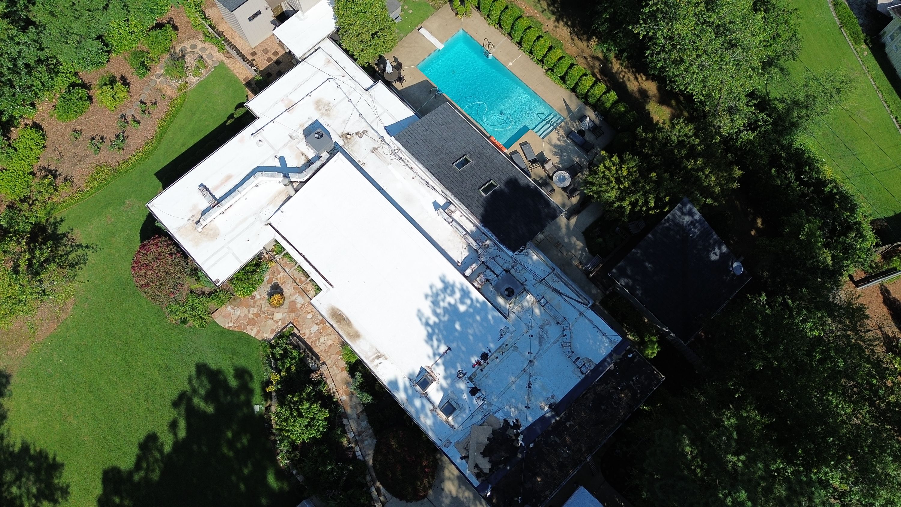 Looking down, the contrast between flat roofing and shingled surfaces is clear.