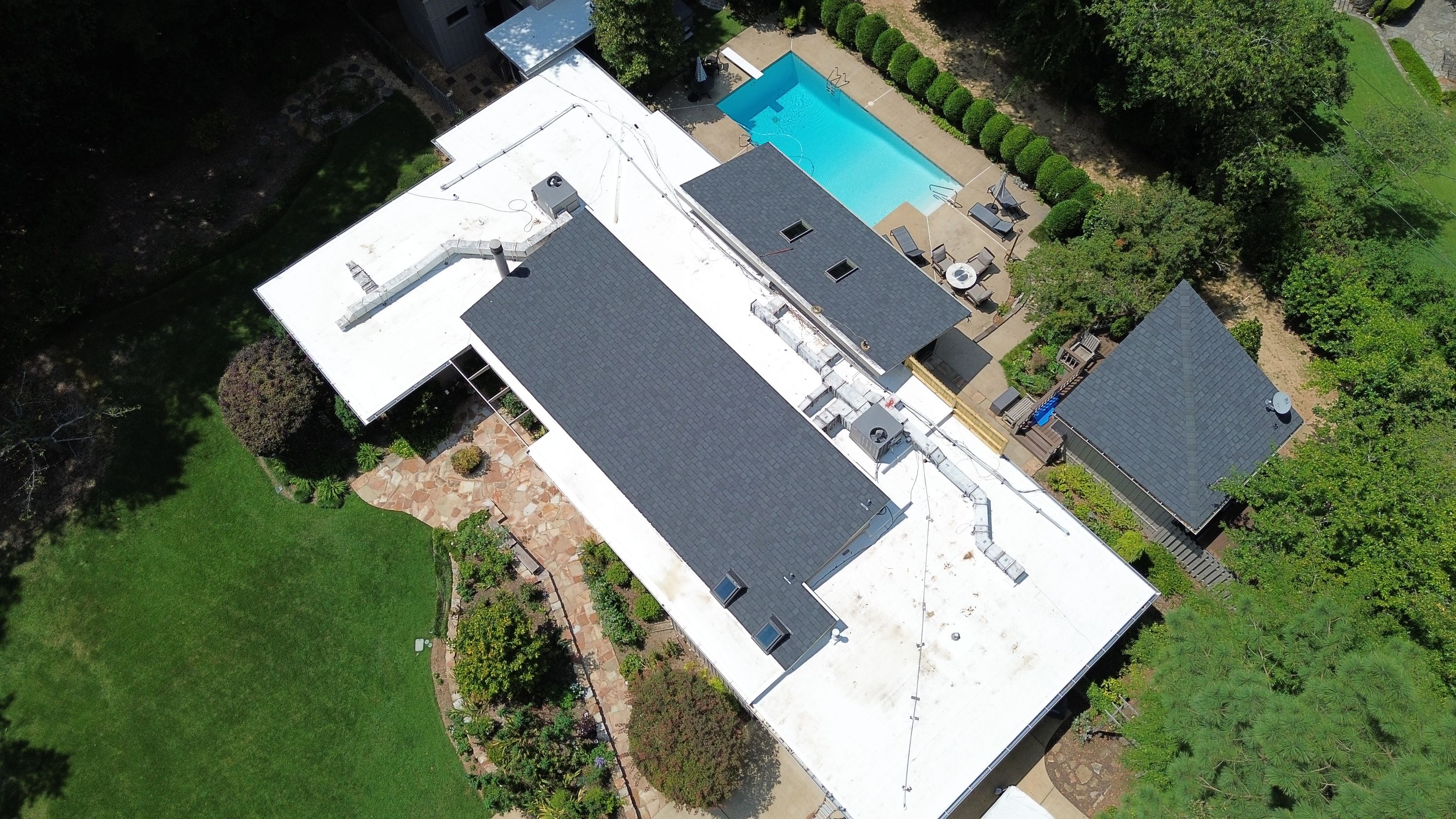 An aerial perspective shows the finished layout of dark shingle sections and flat roofing along Montevallo Rd.