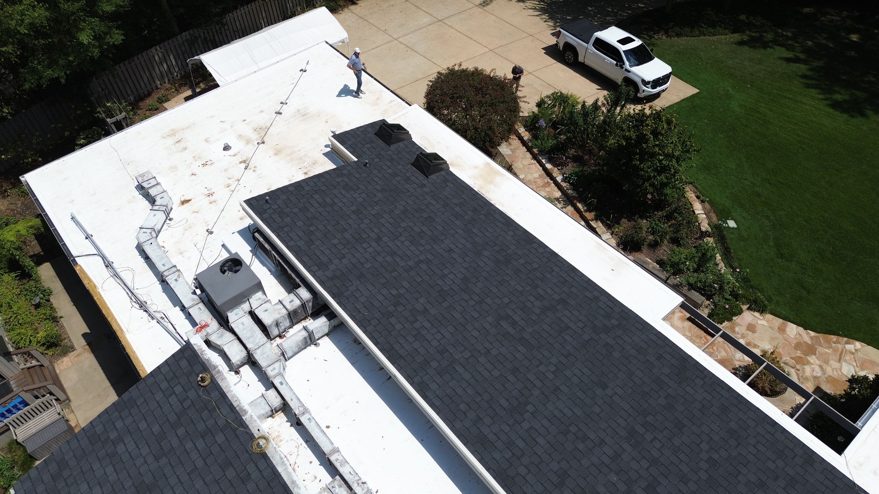 Two dark skylights are integrated into a newly shingled roof section during a Mountain Brook roof replacement.