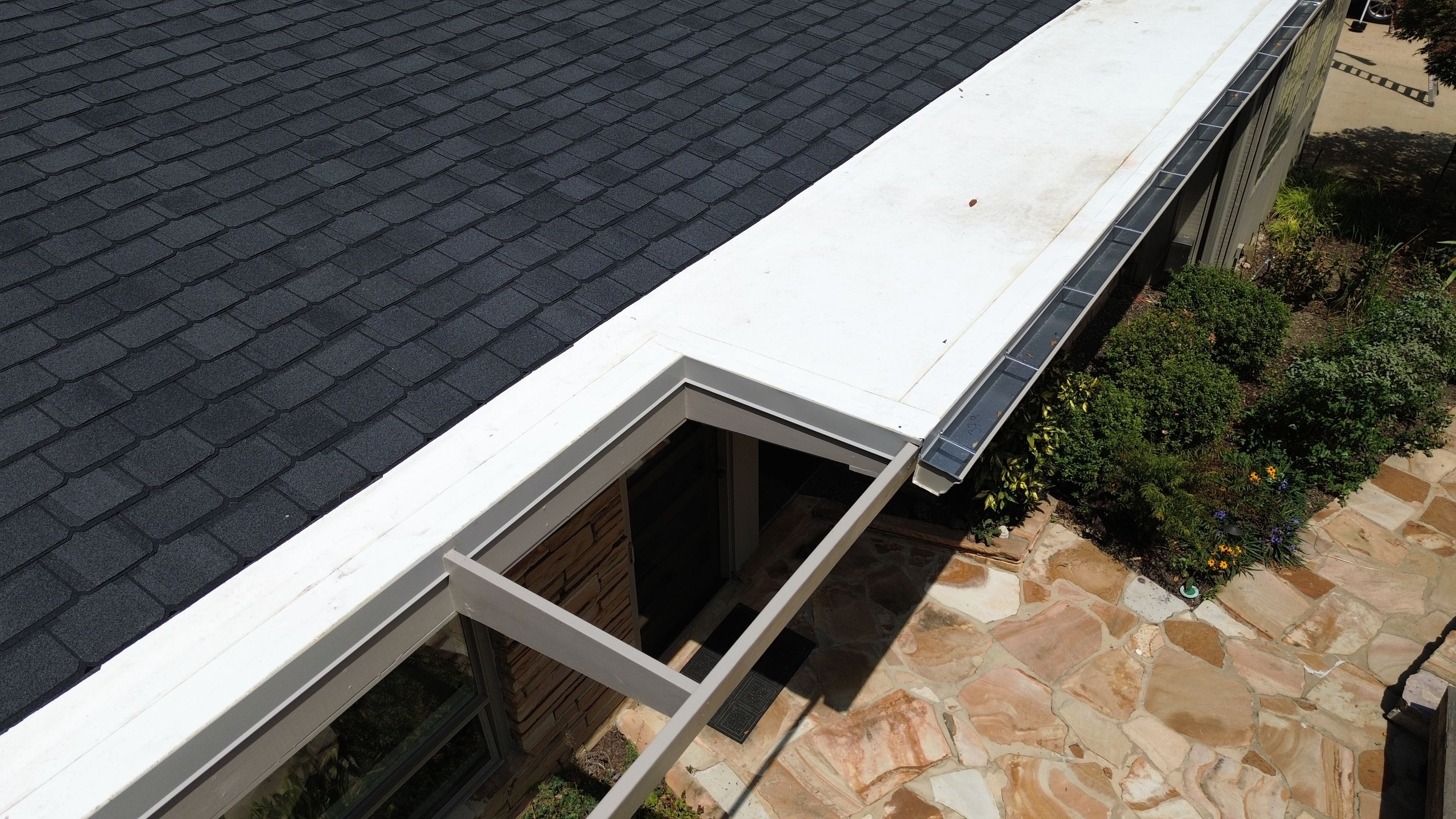 A white open-frame entryway structure sits beneath the newly completed roof replacement.