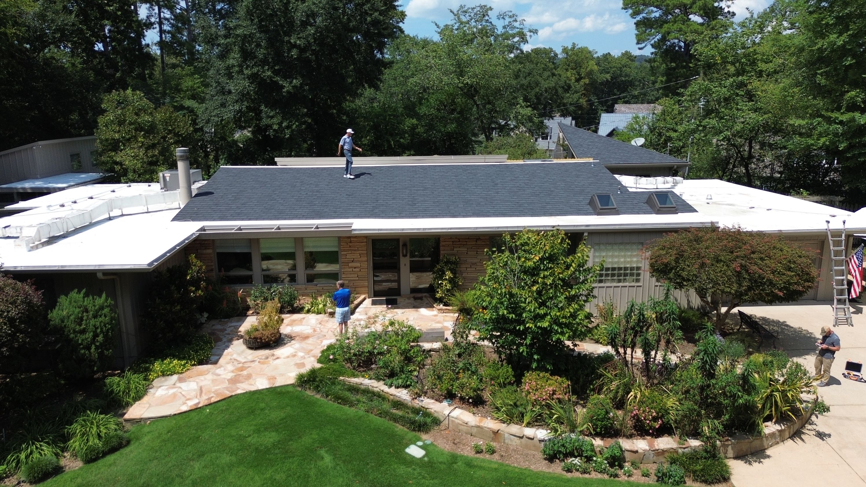 An elevated view highlights the finished shingle roof replacement above a landscaped Crestline entry.