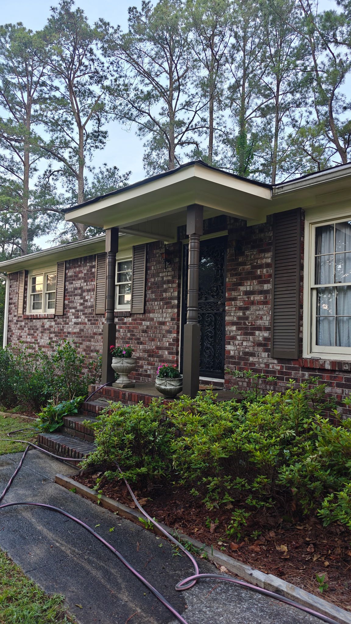 Completed front porch roof repair showcases clean brown fascia and trim work on this Leeds residence.