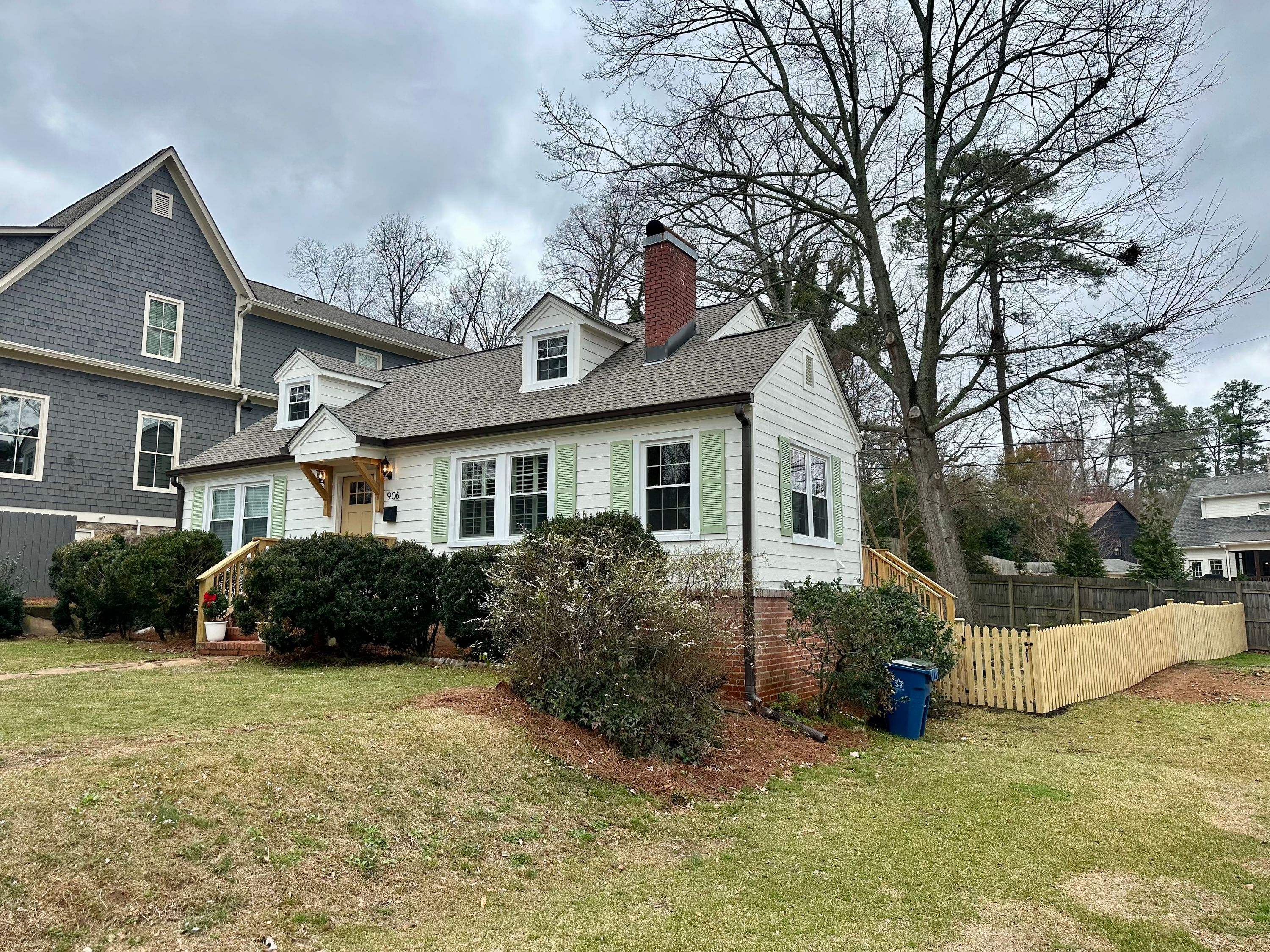 White cottage in Homewood featuring new siding installation, roof replacement, and white window replacement.