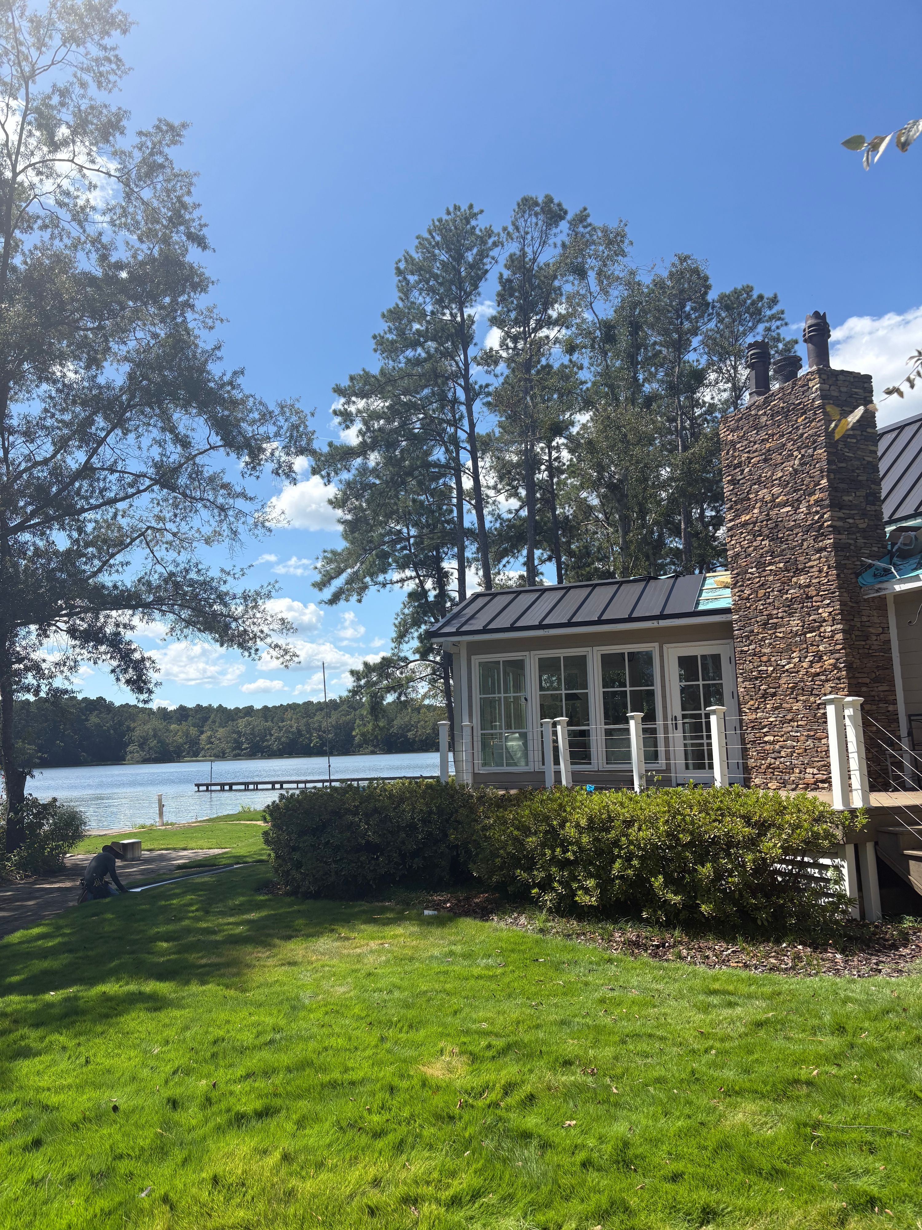 A completed standing seam metal roof section overlooks the water at a lakeside Wilsonville home.