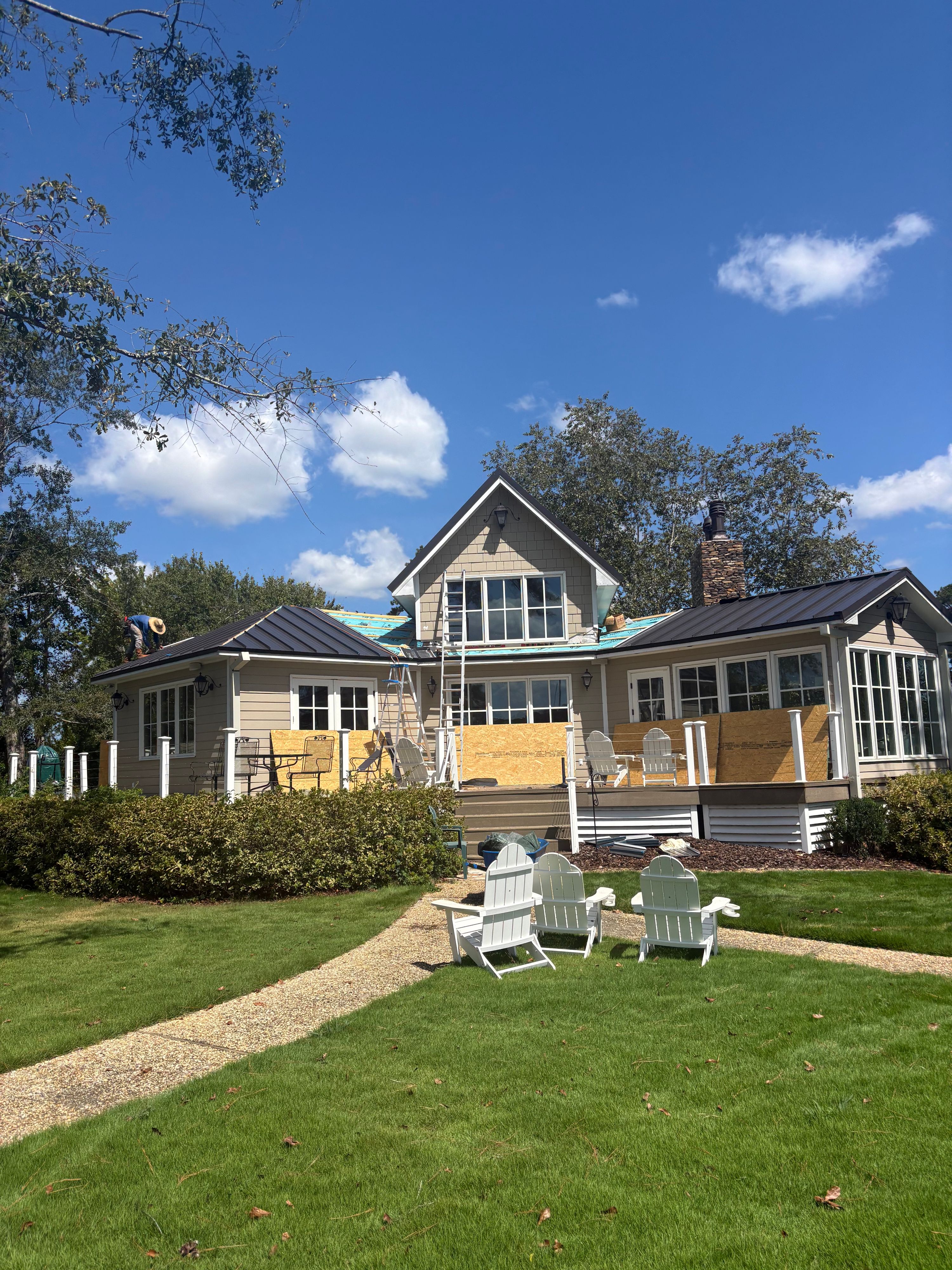 Ladders stand against the siding during the initial phase of a Birmingham roof replacement.