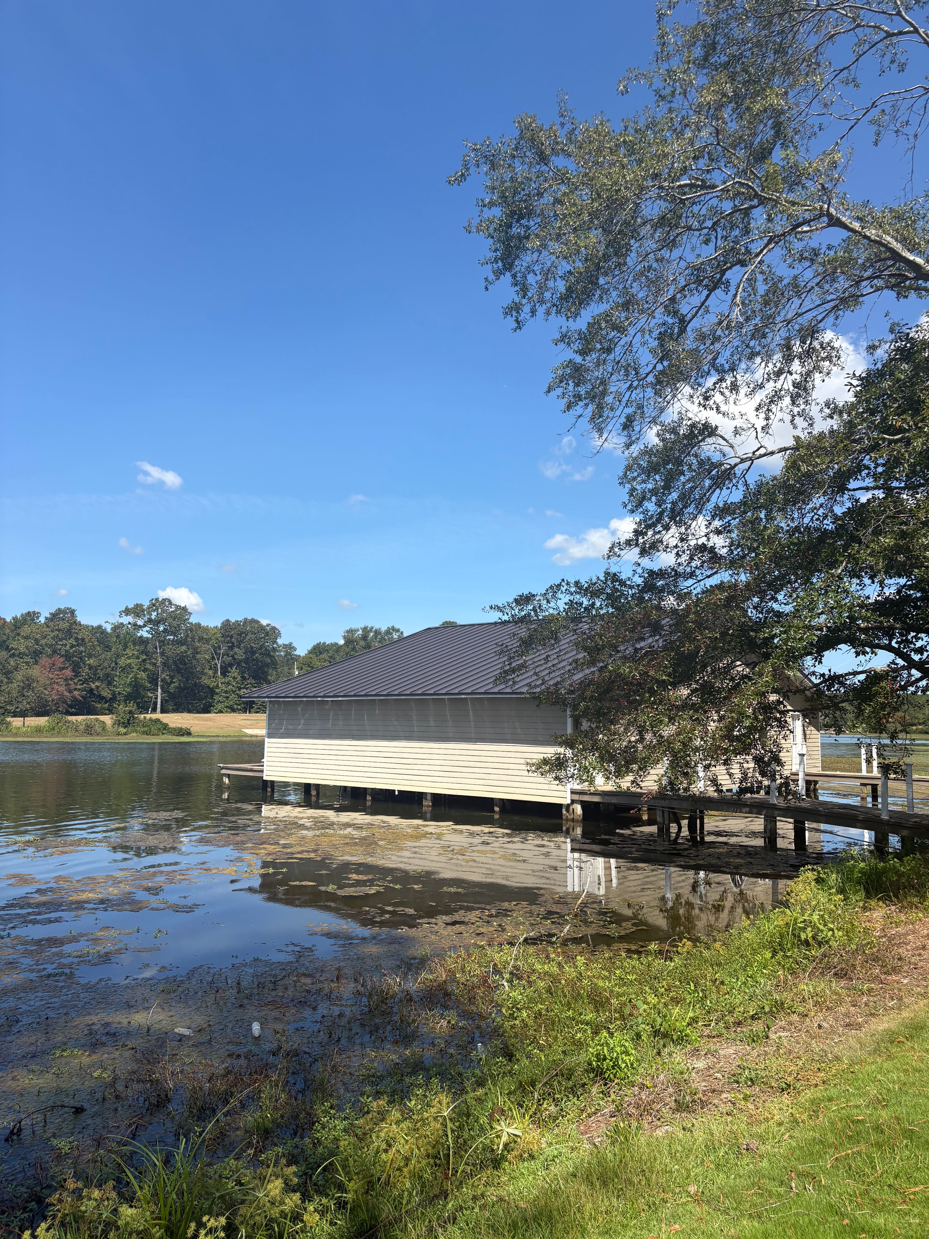 A boathouse on Lay Lake features a newly completed standing seam metal roof over beige siding.
