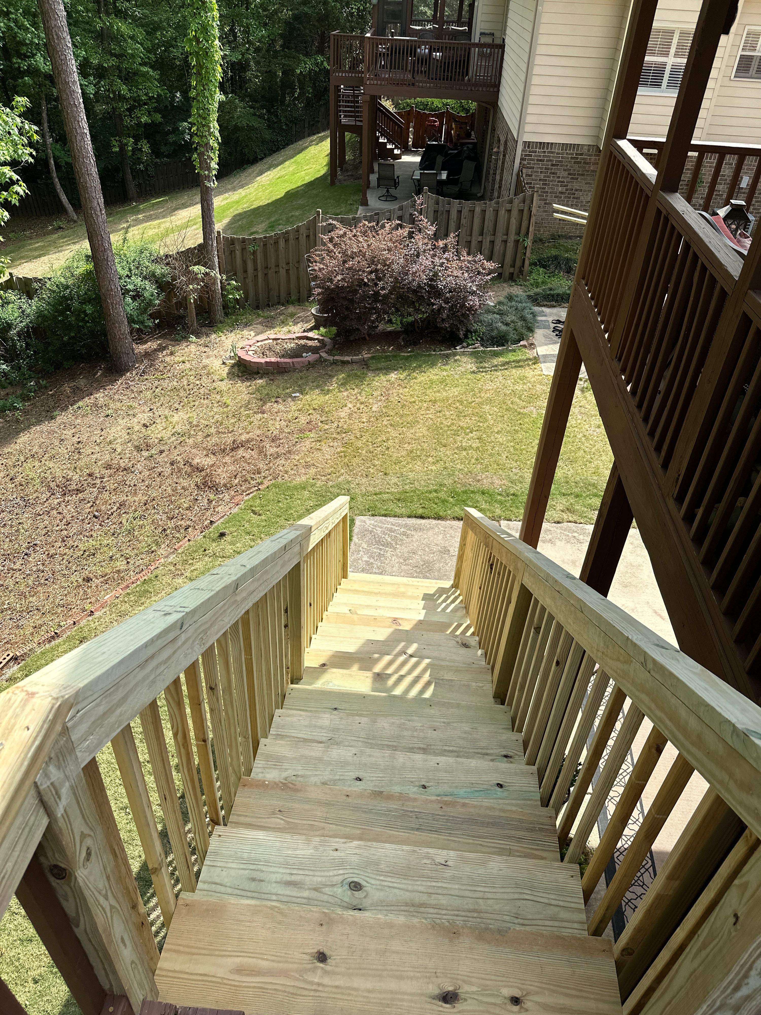 A view down new pressure-treated wood stairs built for a custom deck in a Helena backyard.