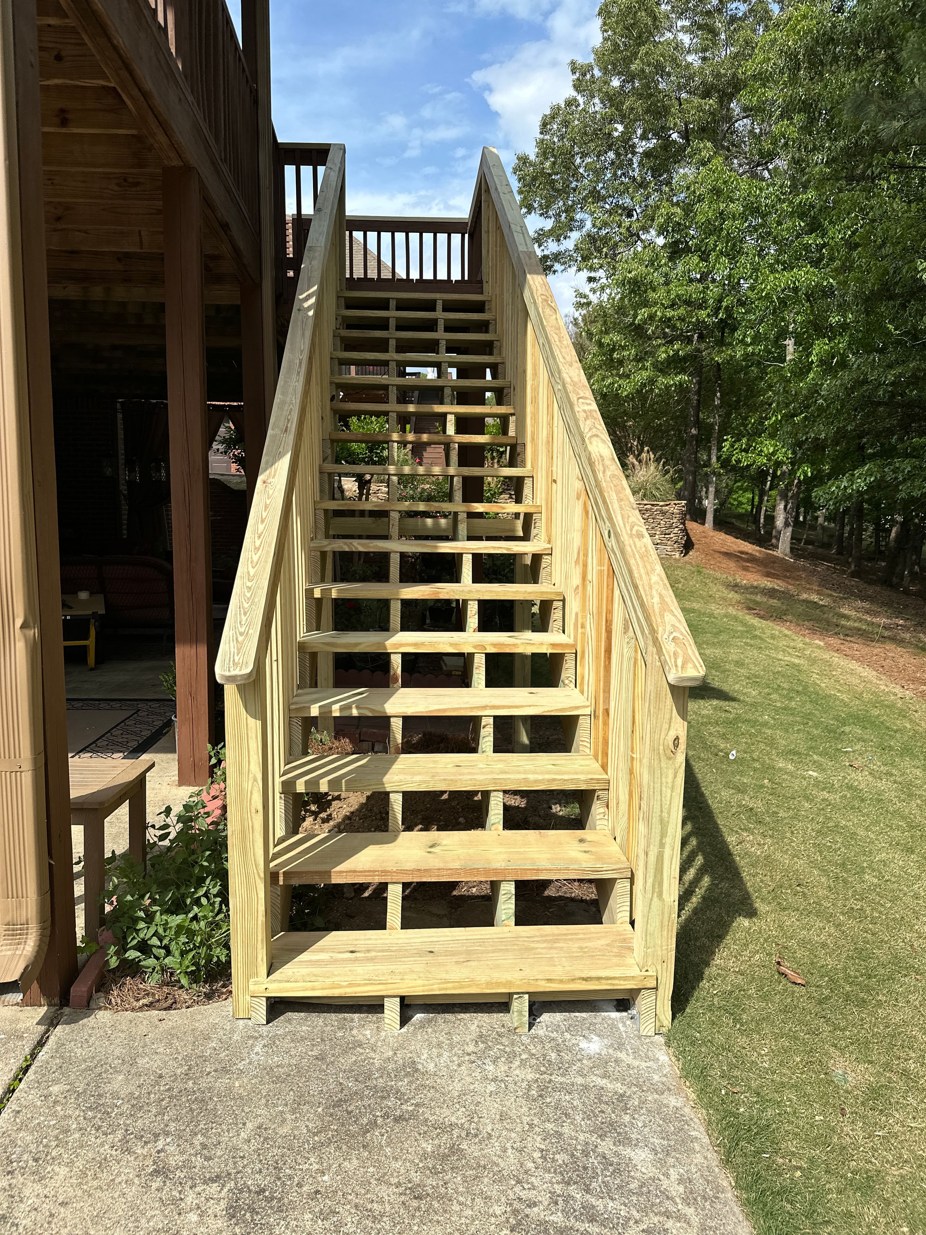 Newly constructed pressure-treated wooden stairs leading to a custom deck at a home in Helena.