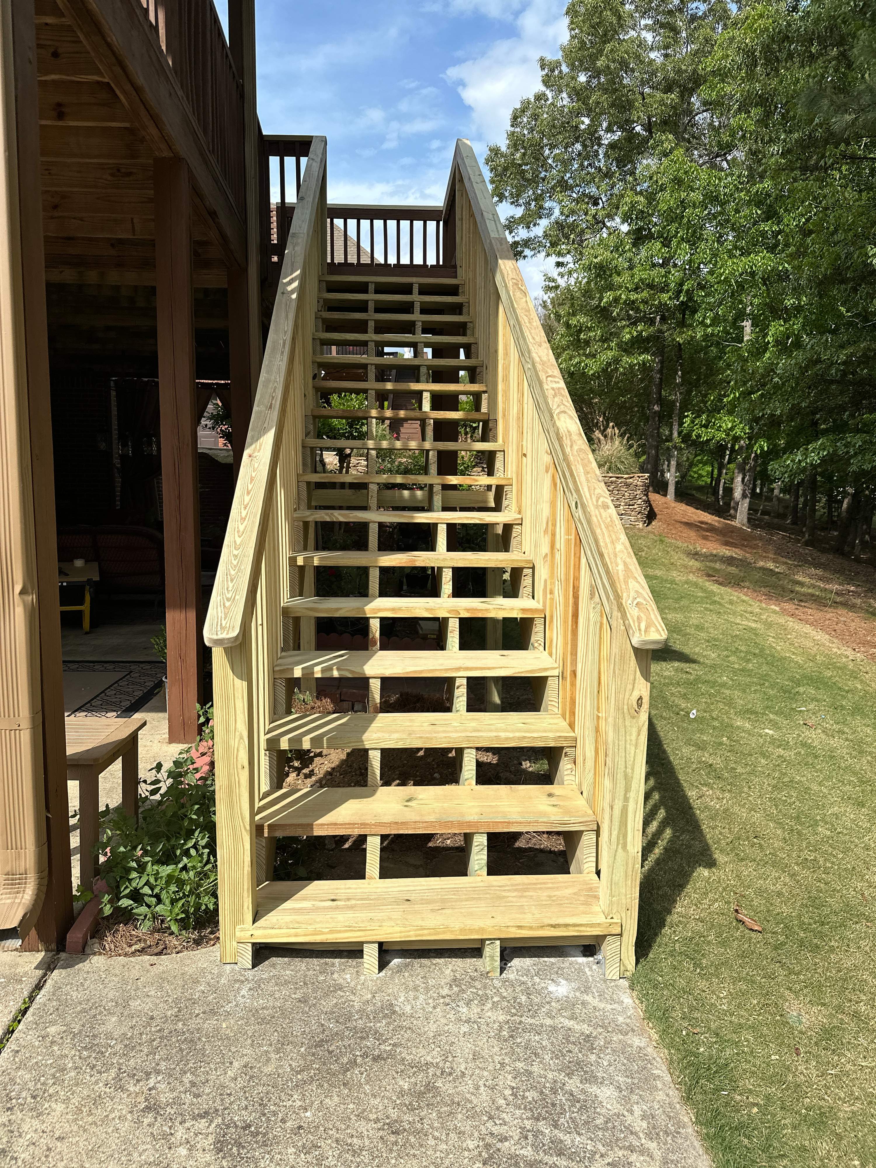 Newly constructed pressure-treated wooden stairs leading to a custom deck at a home in Helena.