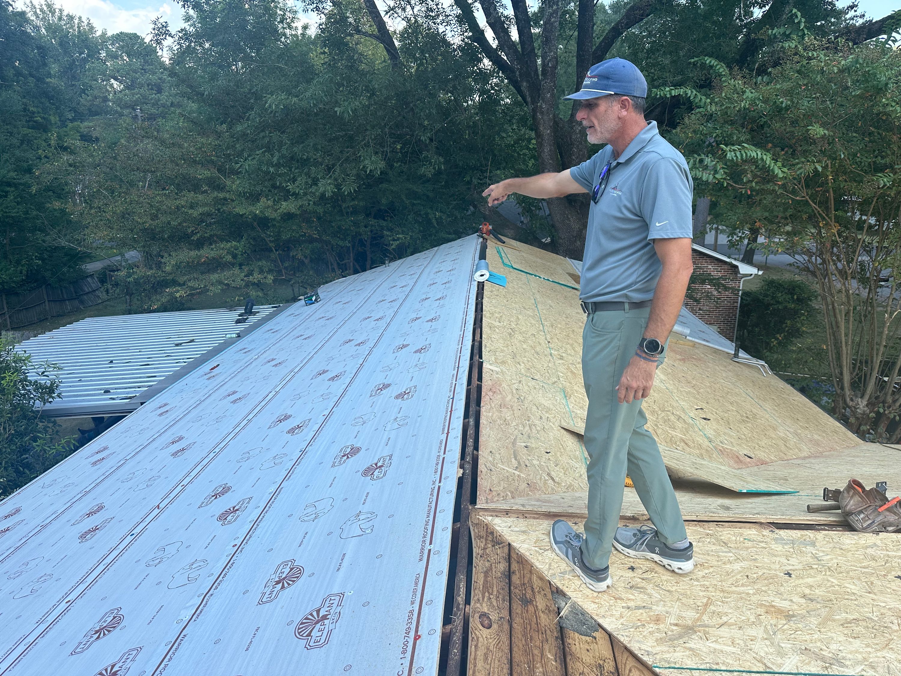 Roofing professional inspecting new underlayment during a Crestline Gardens roof replacement in Birmingham.