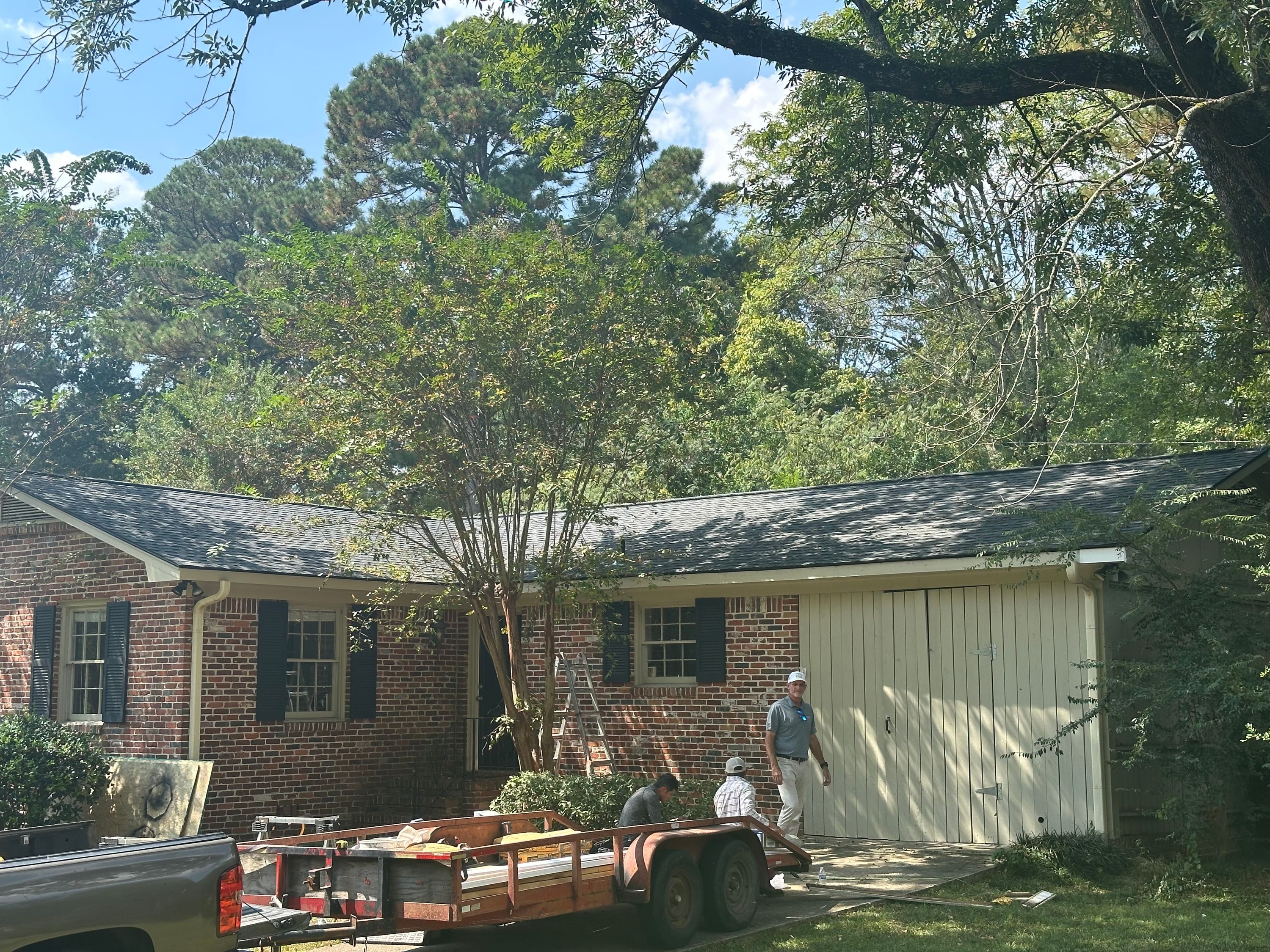 Completed roof replacement with dark shingles on a brick house in Crestline Gardens, Birmingham.