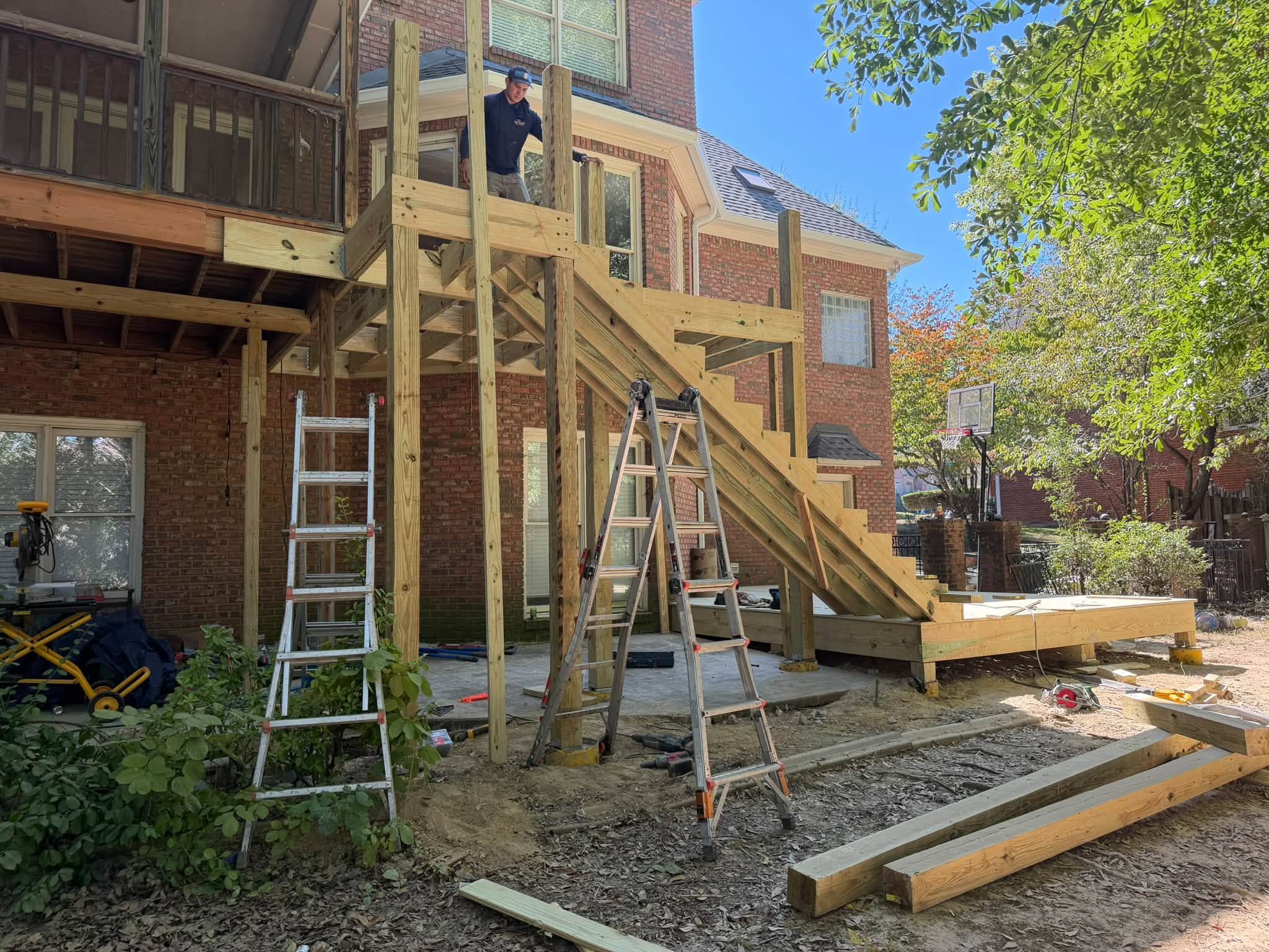Framing the stair stringers and support posts for an elevated custom deck installation.