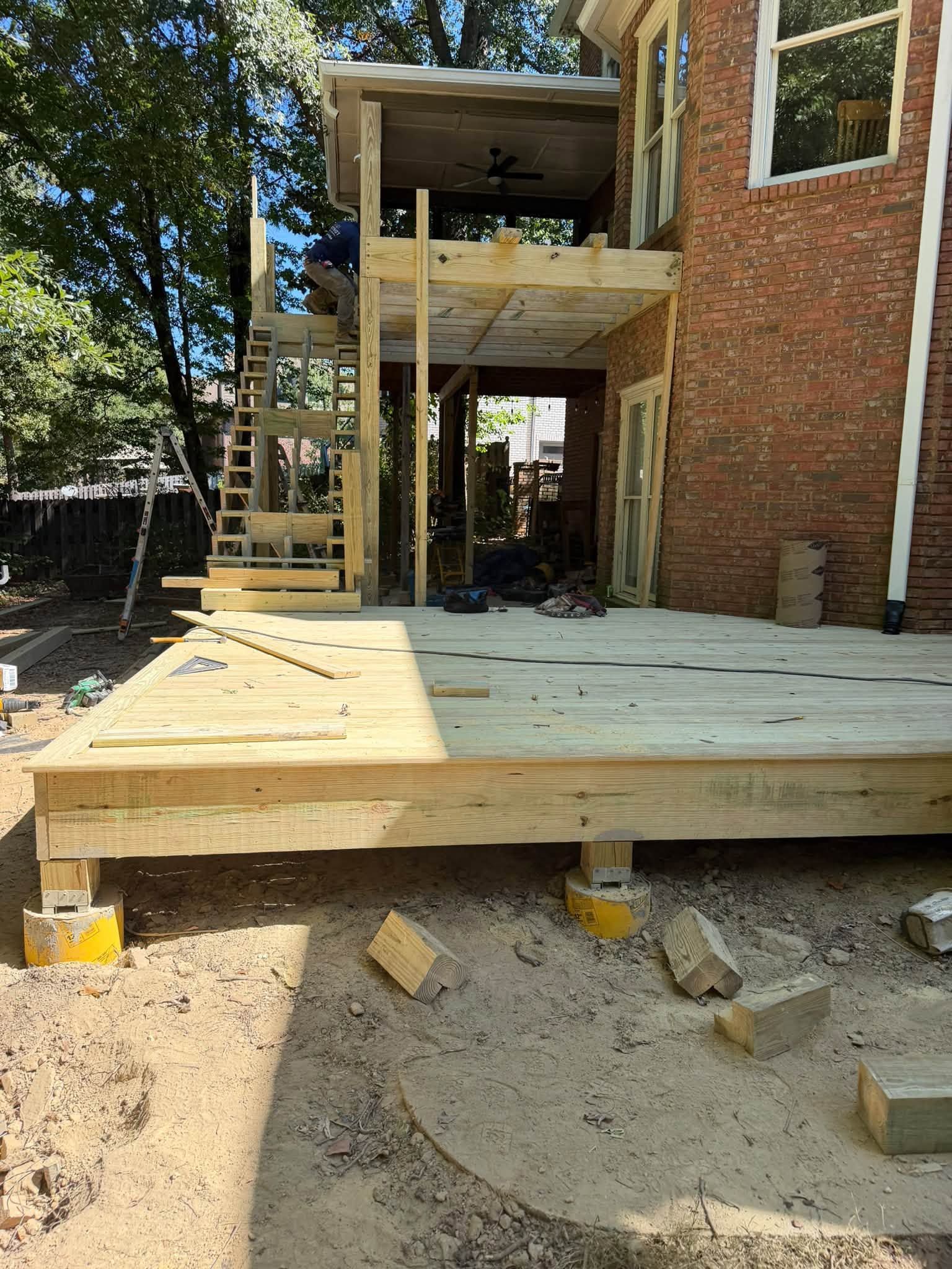 Concrete piers and footings anchor the lower platform during a custom deck build in Hoover.