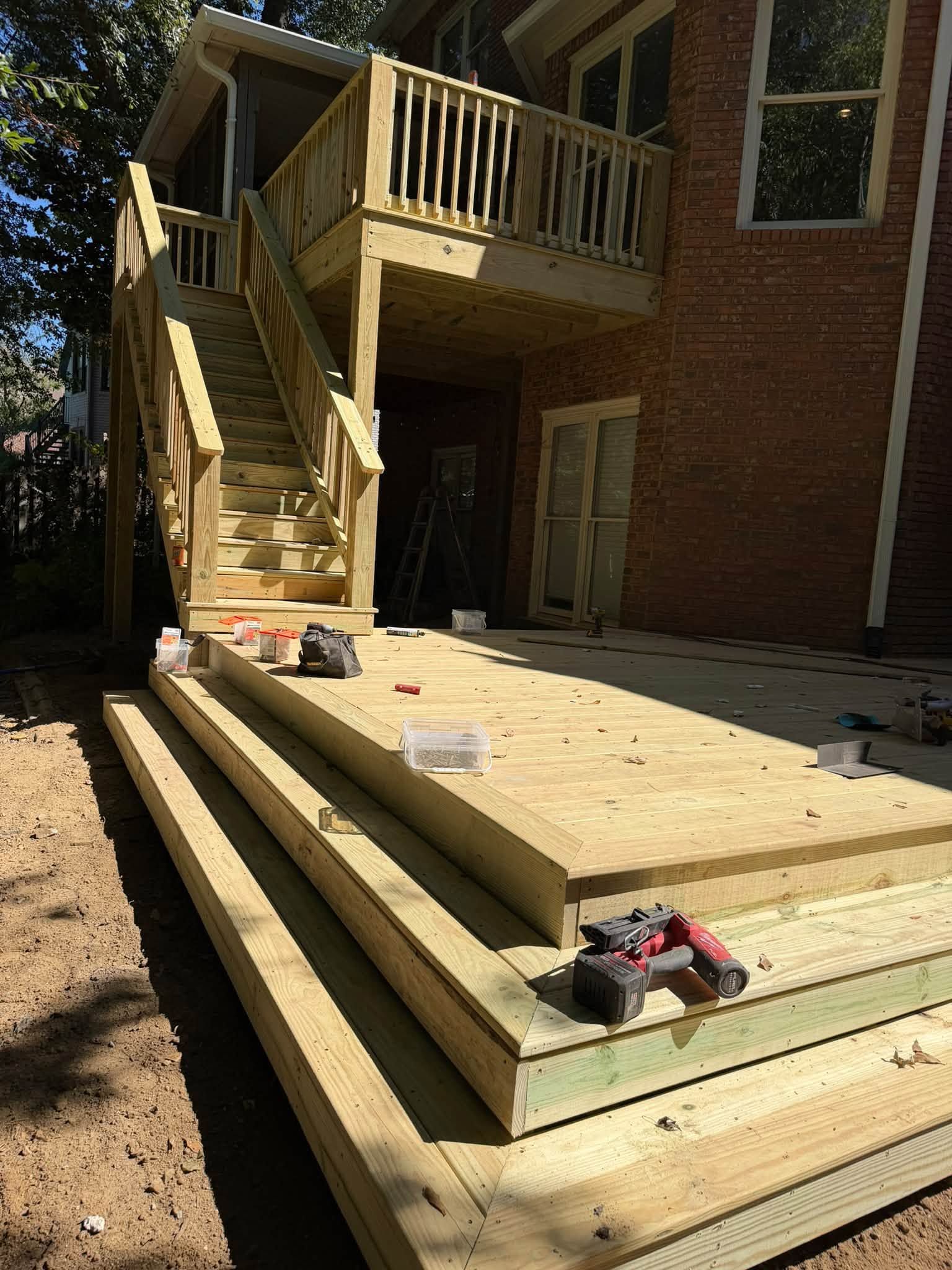 Picture-frame edging details installed along the perimeter boards of a new lower deck surface.