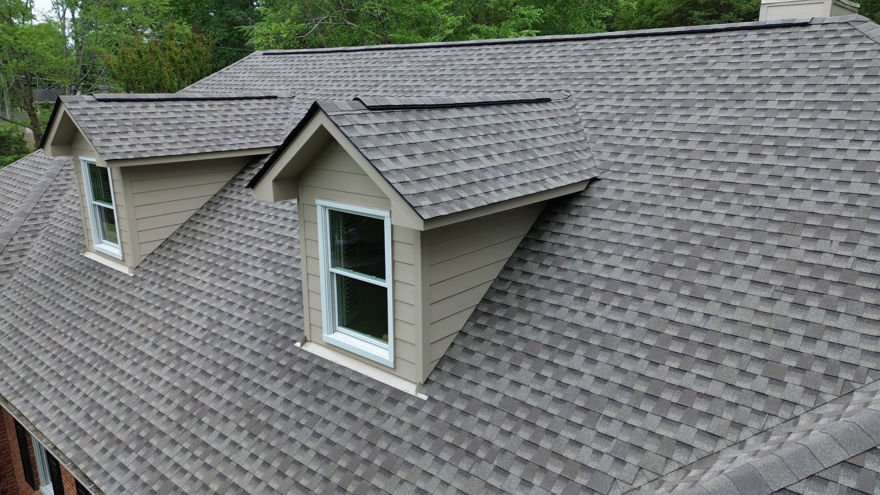 A new shingle roof replacement with beige siding on dormer windows at a home in the Carisbrooke neighborhood of Hoover.
