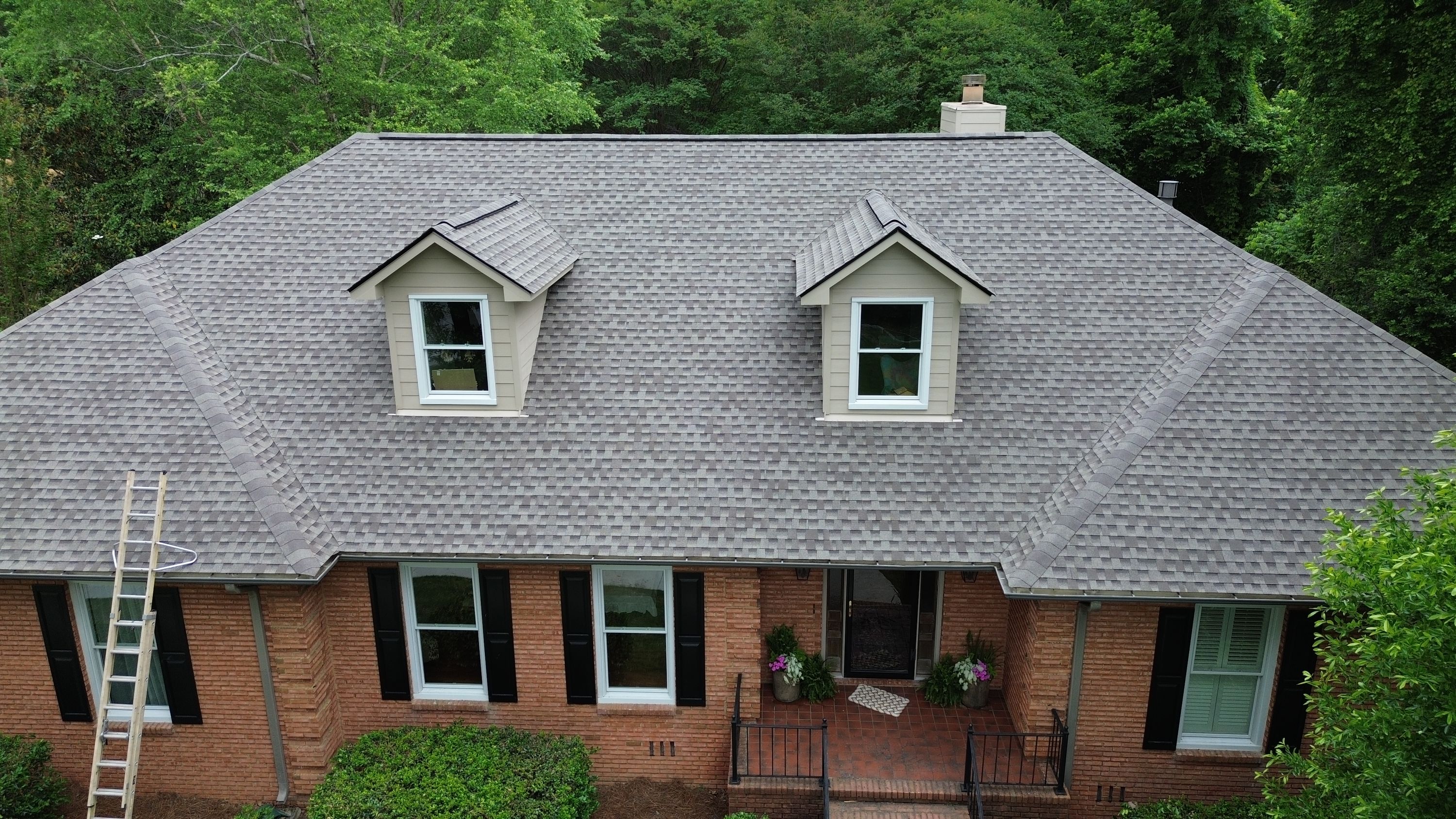 A newly installed gray shingle roof and dormers on a brick home in the Carisbrooke neighborhood of Hoover.