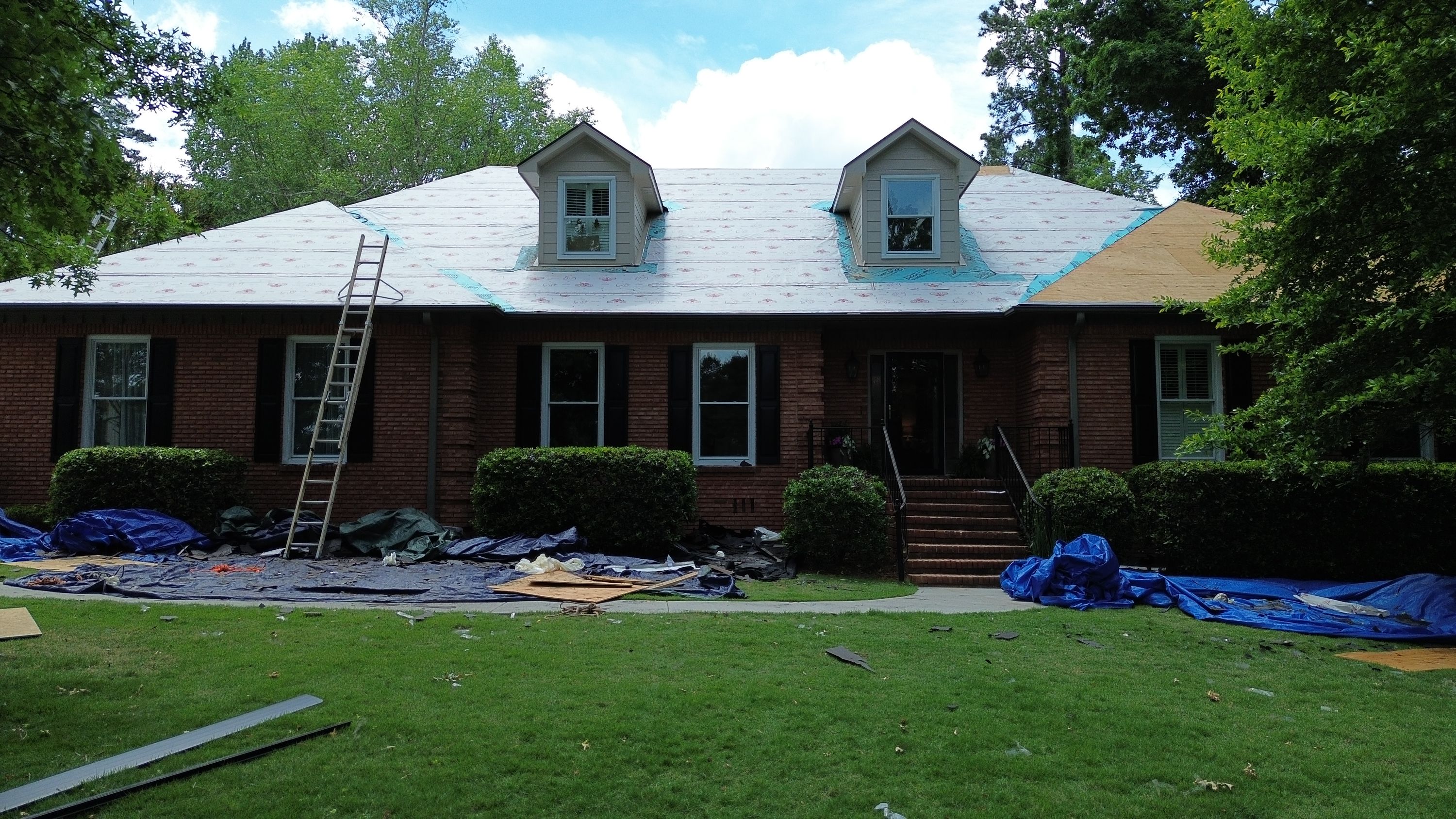 Roof replacement in progress on a brick home in the Carisbrooke neighborhood of Hoover.