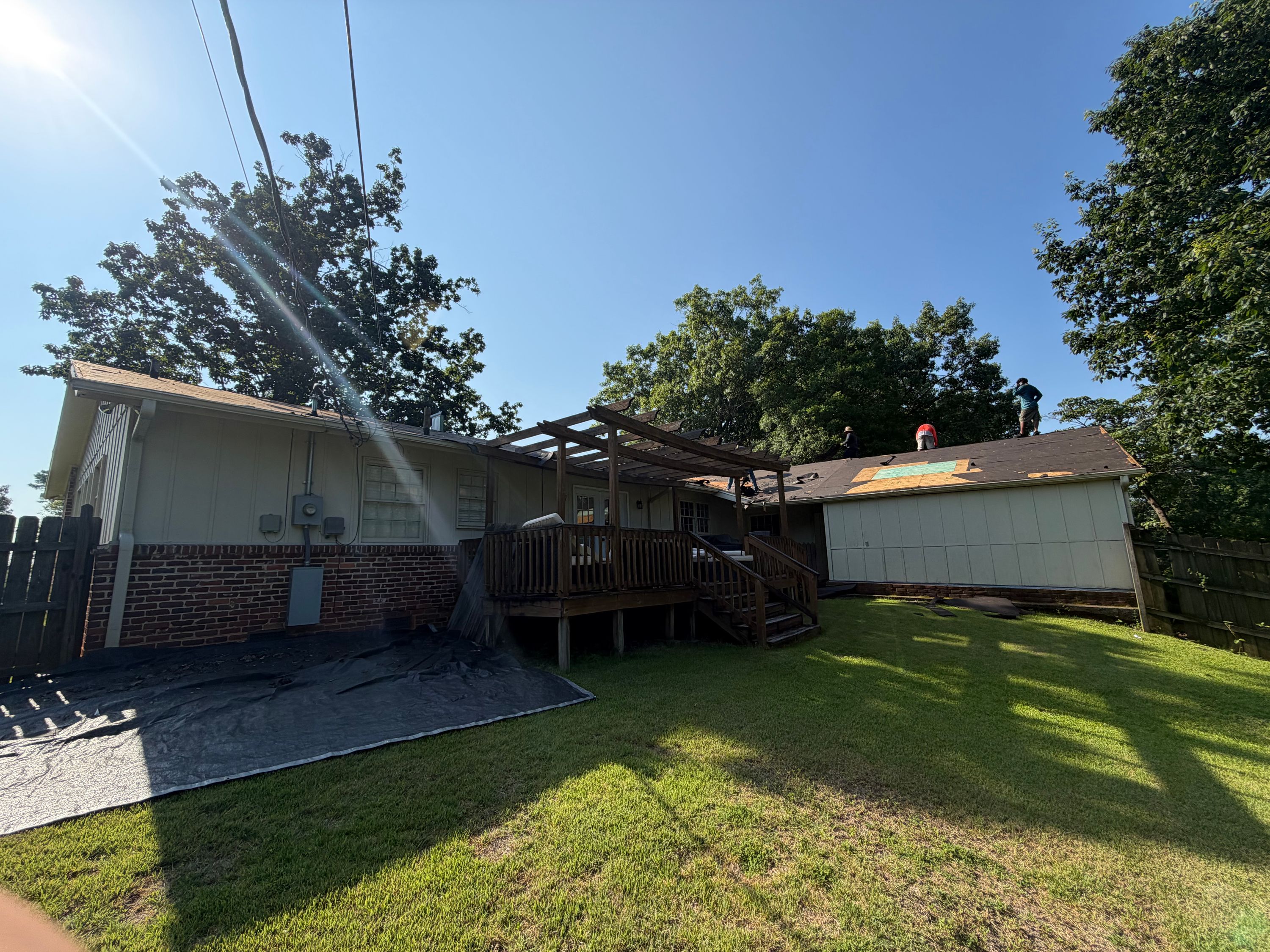 Wooden deck stairs and a weathered pergola stand attached to the rear of this home on Columbiana Road.