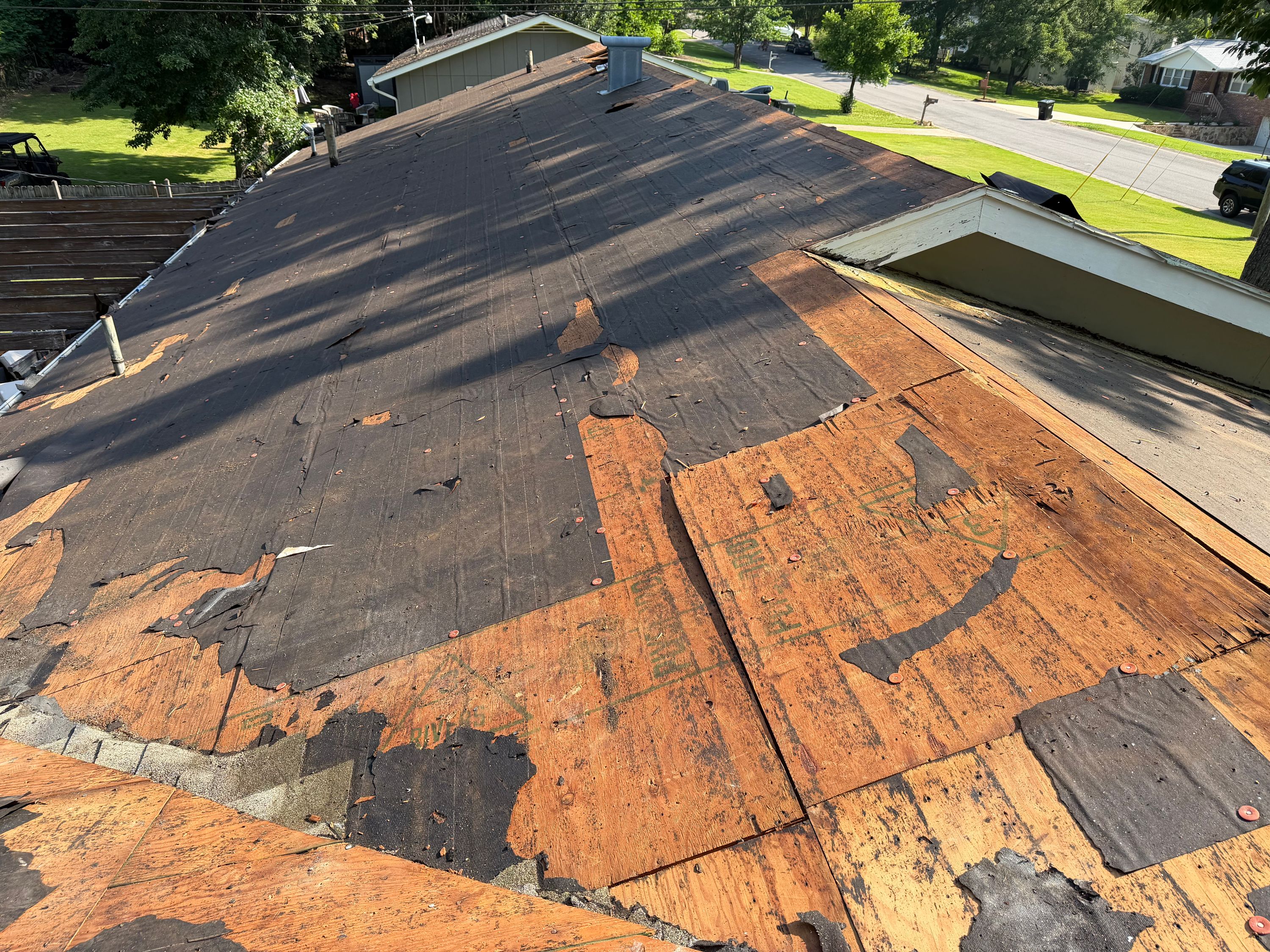 Exposed plywood decking is visible on this residential roof during a full roof replacement in Vestavia Hills.