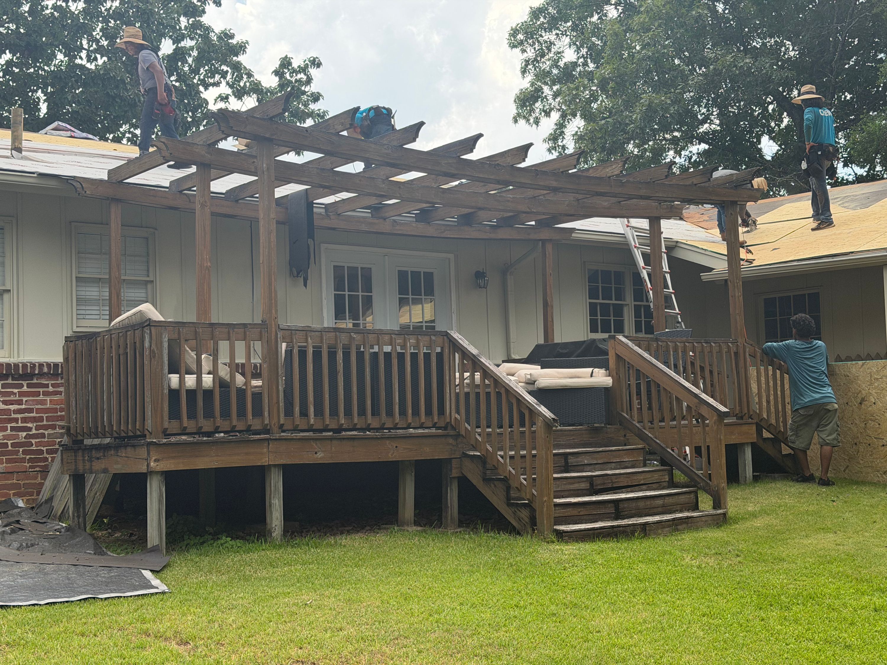 Weathered timber rafters of a backyard pergola sit above the wooden deck stairs on Columbiana Road.
