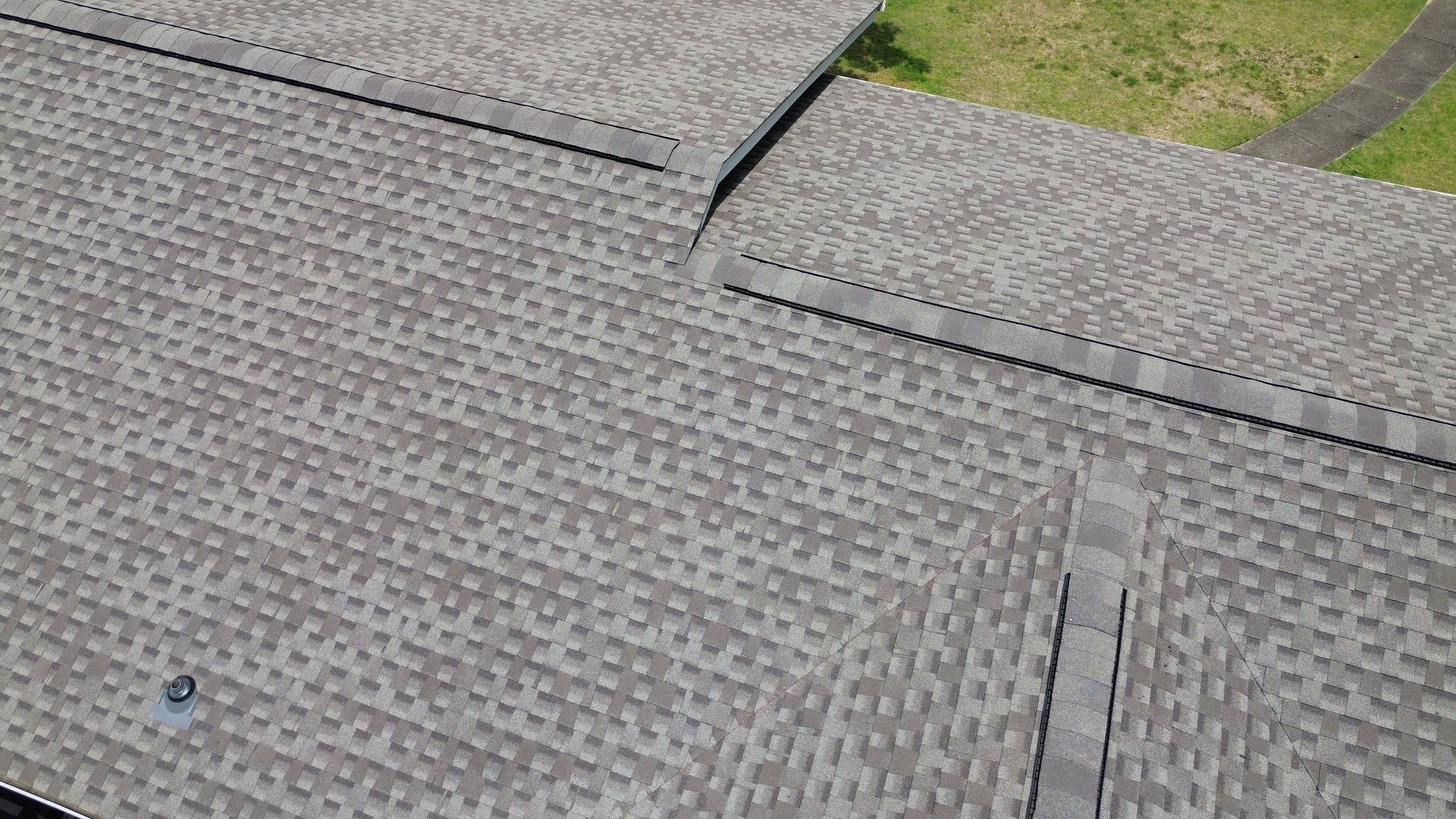 Detailed view highlights the precise alignment of shingles along the intersecting valleys of a roof replacement.