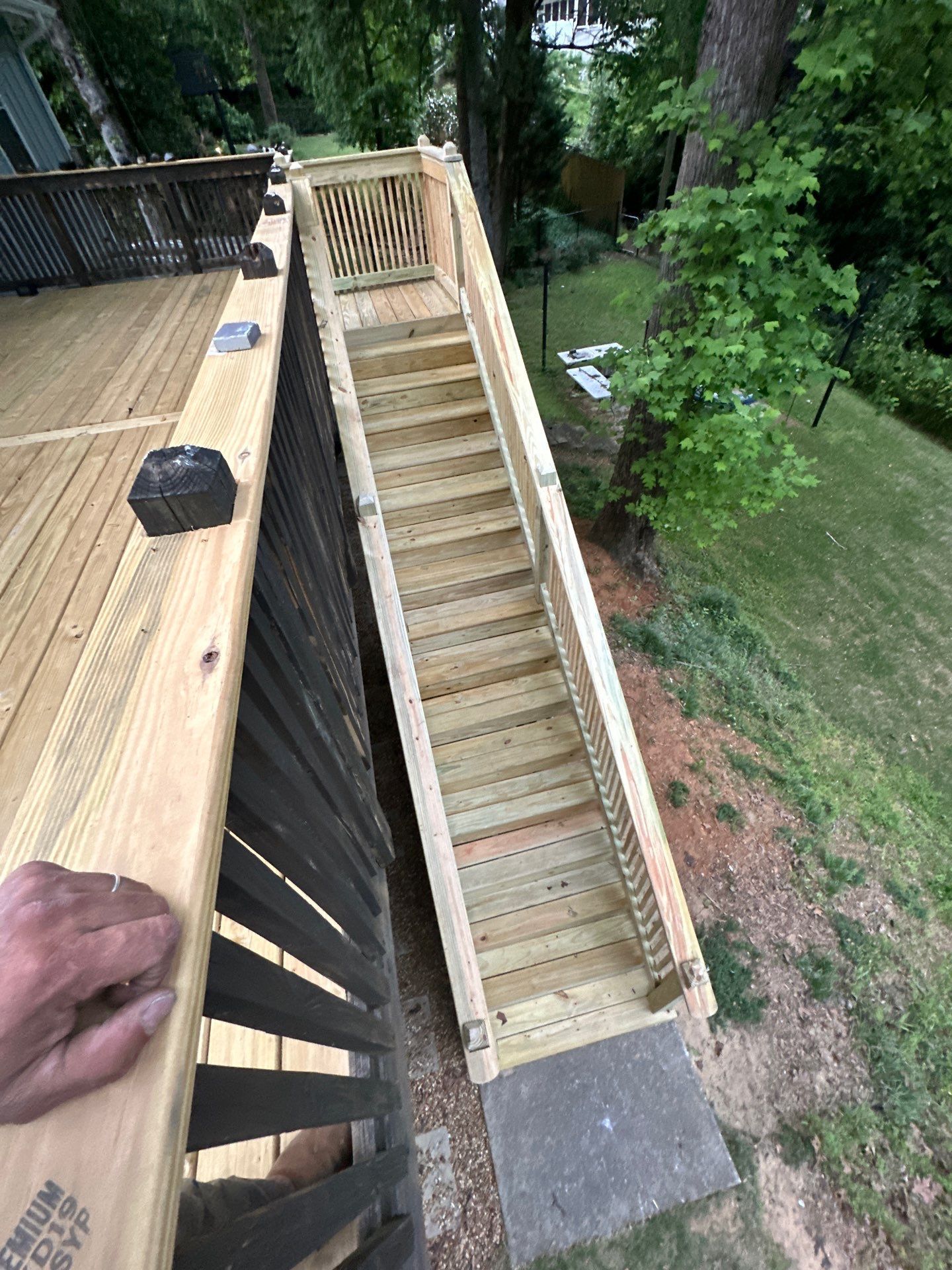 A newly constructed wooden deck staircase leading down into a backyard in Vestavia Hills.