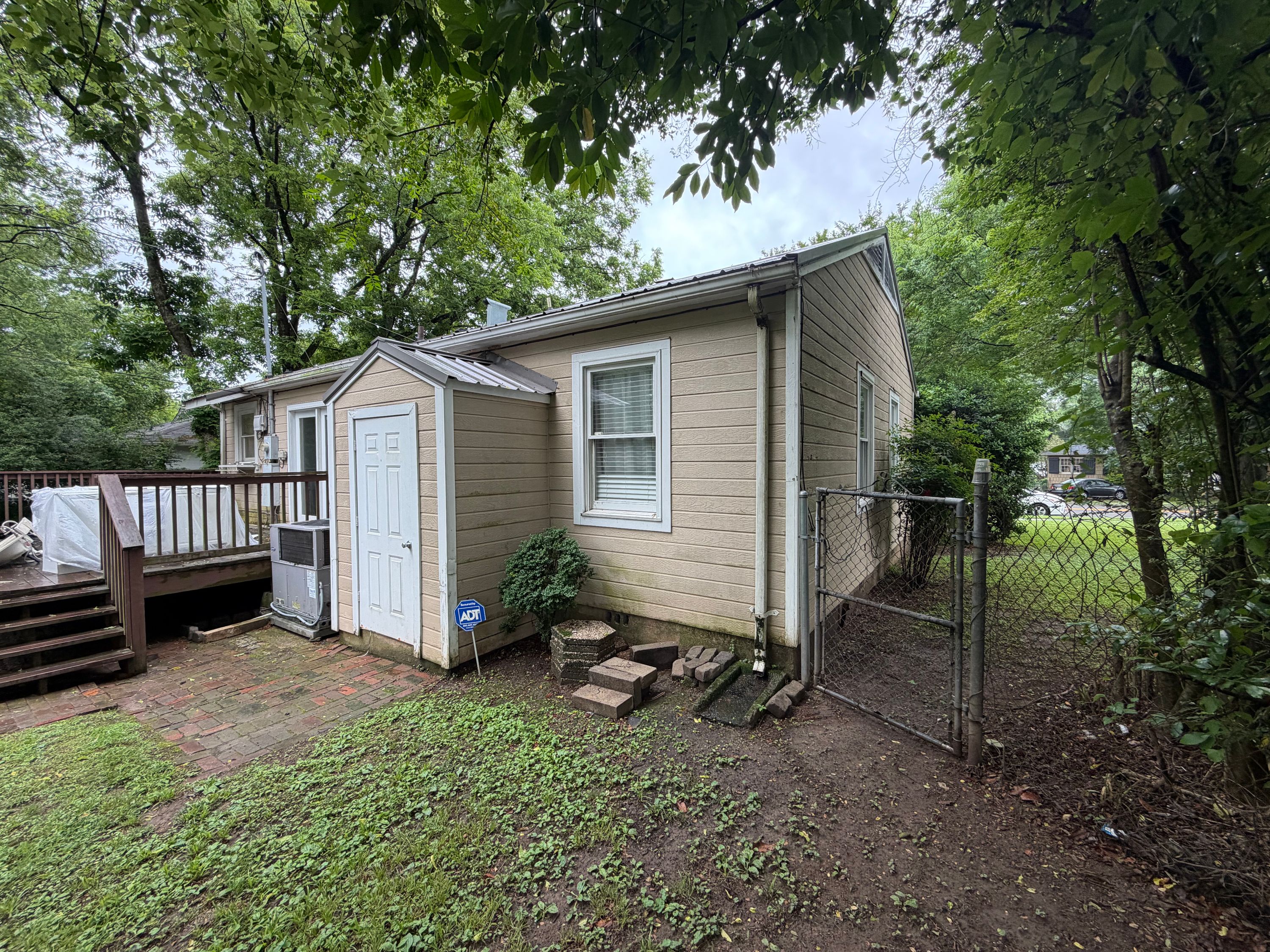 A house in West Homewood featuring installed siding, a metal roof, and an attached wood deck.