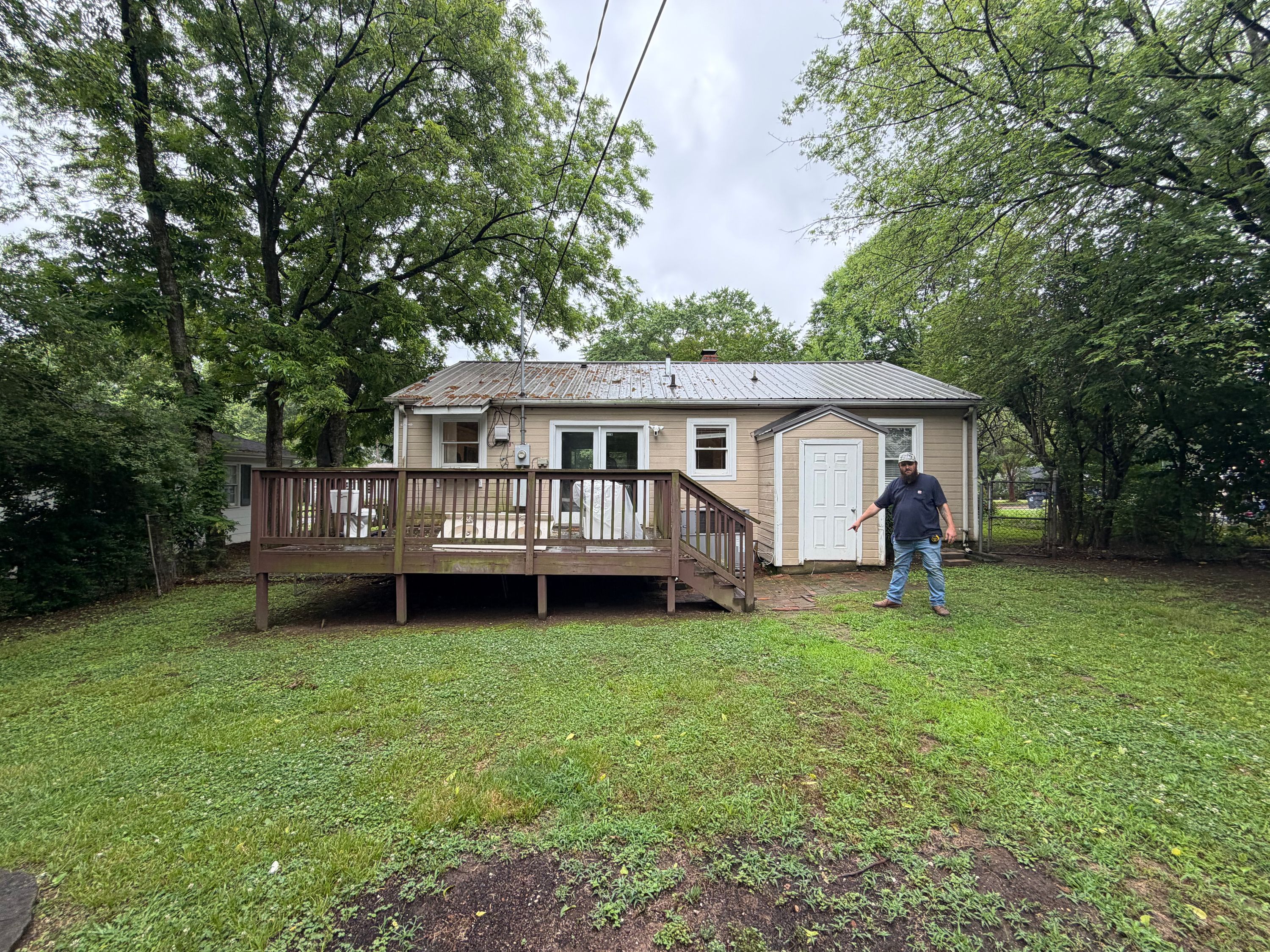 A house with a metal roof and a wooden deck in the backyard of a home located in West Homewood.