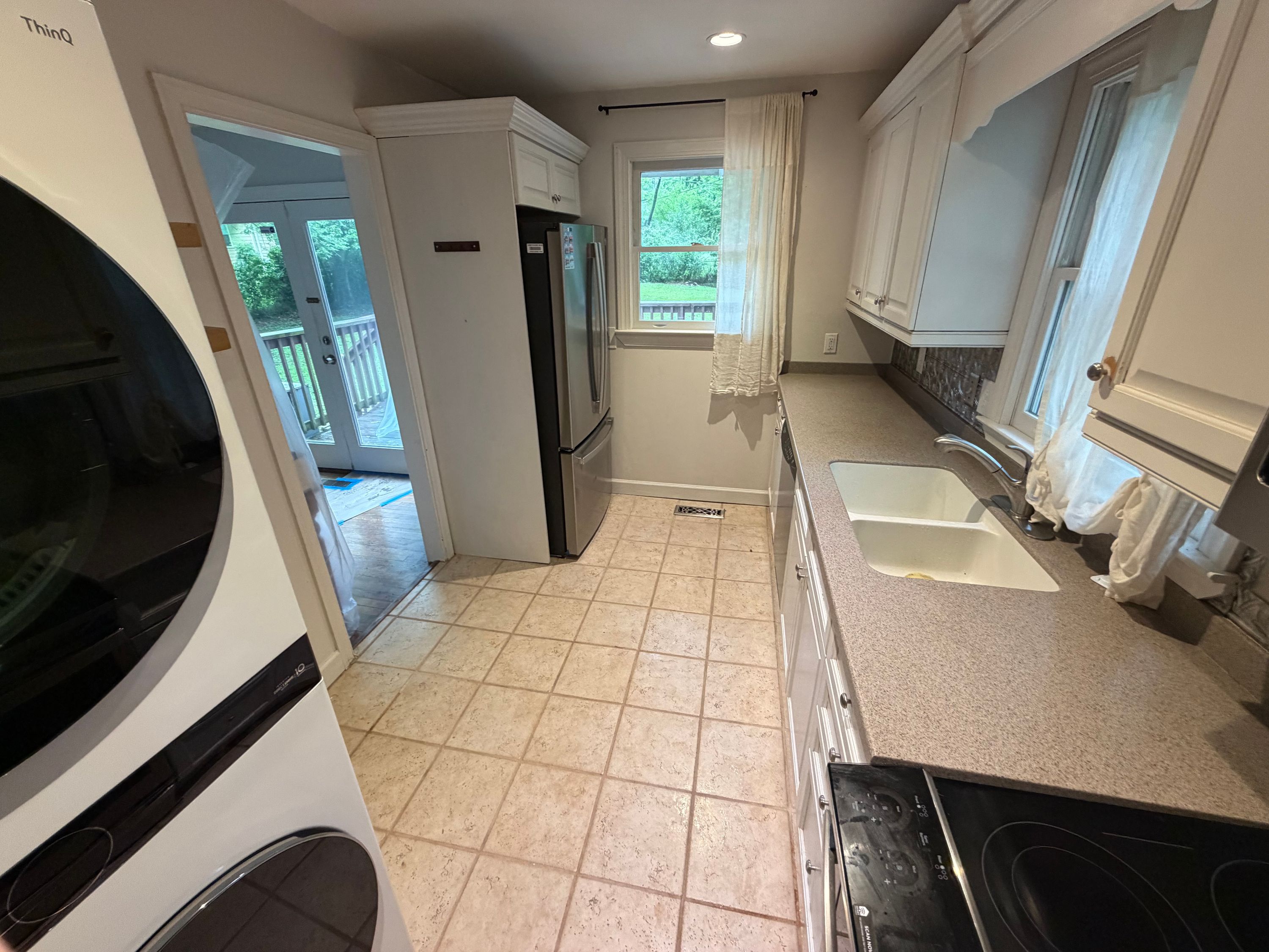 A kitchen featuring white cabinets and new window replacements installed in a home in West Homewood.