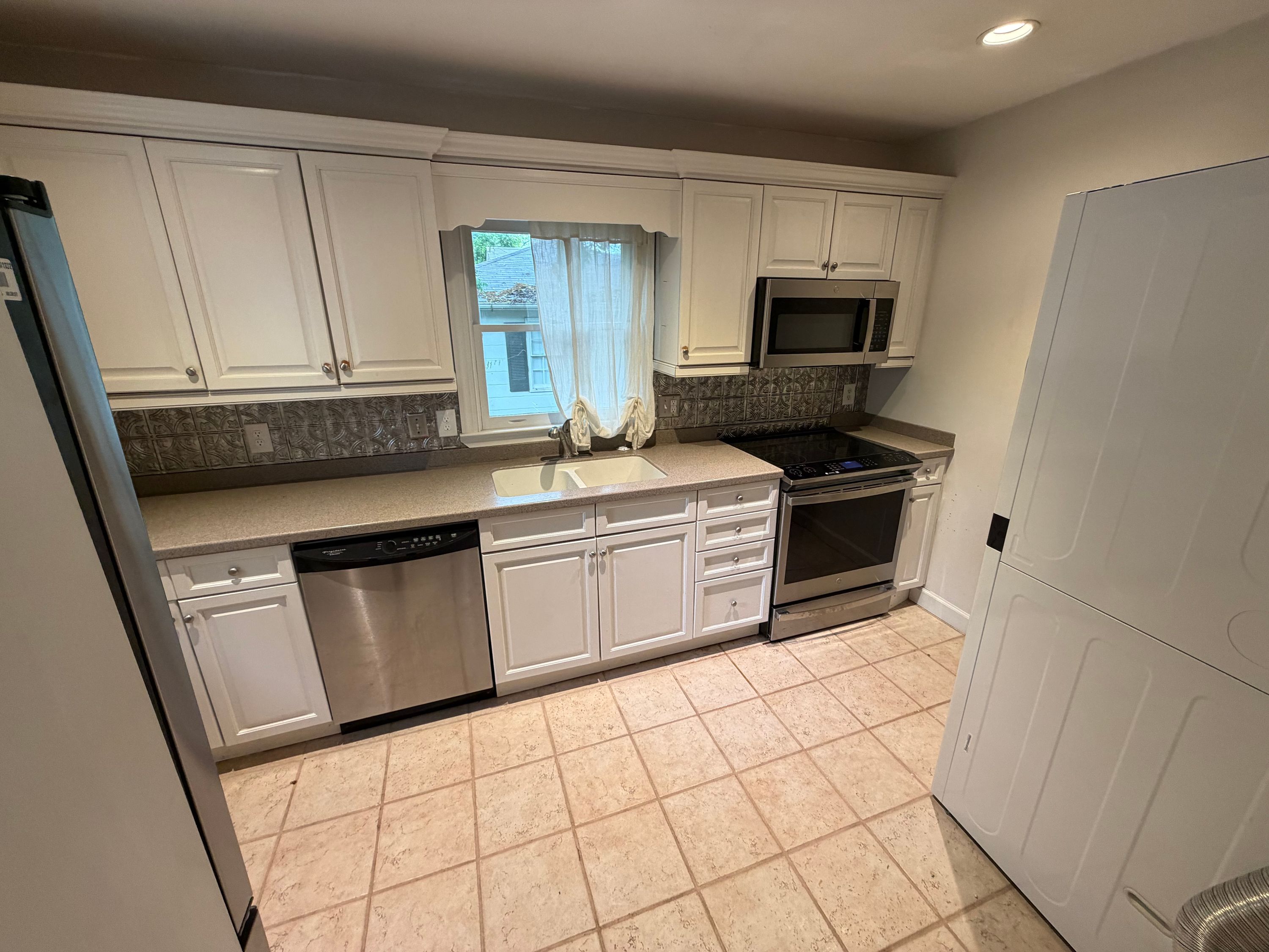 A remodeled kitchen featuring white cabinets and stainless steel appliances in a West Homewood home.