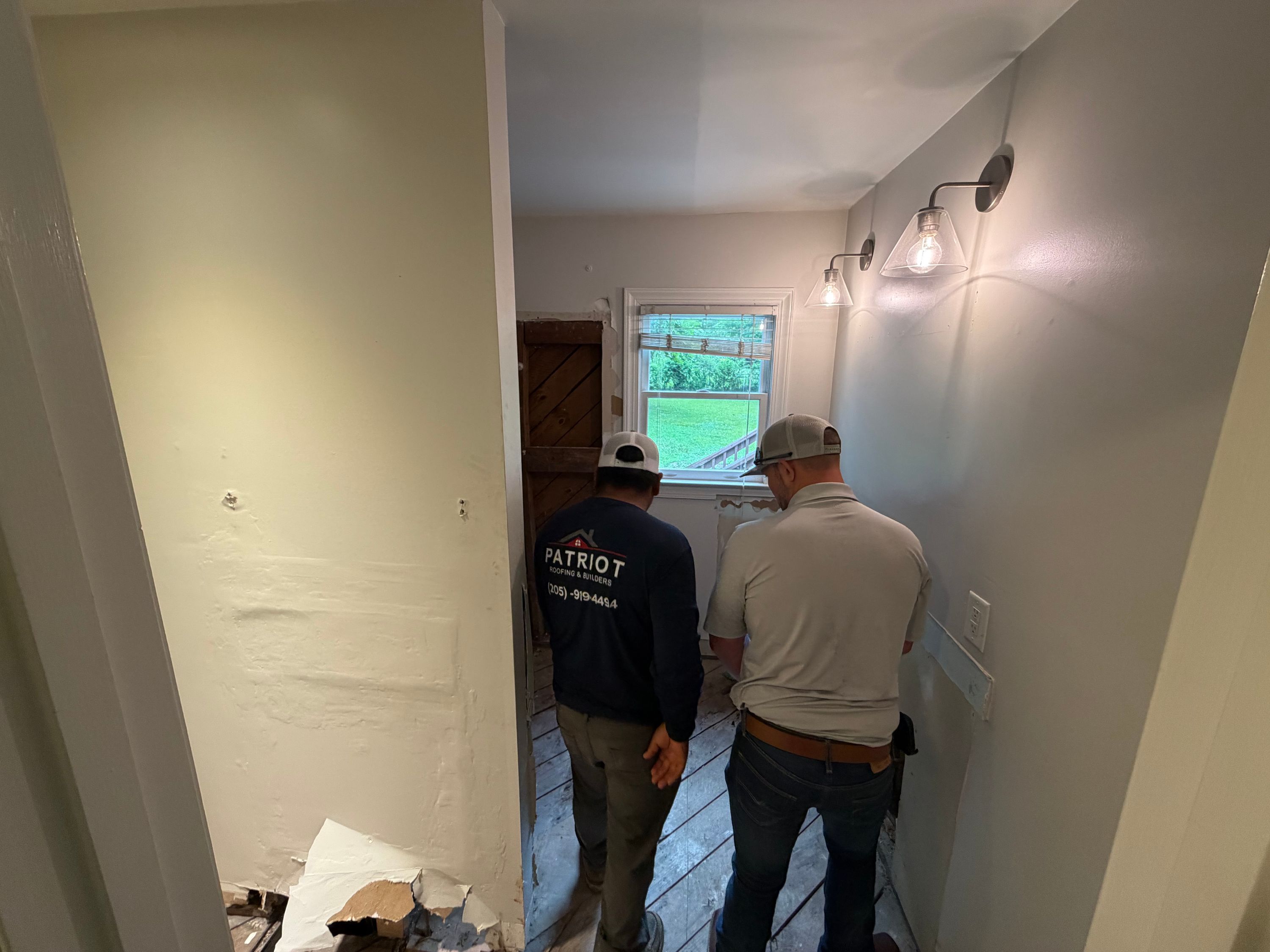 Window replacement project underway in a West Homewood home featuring exposed wall studs and new lighting fixtures.