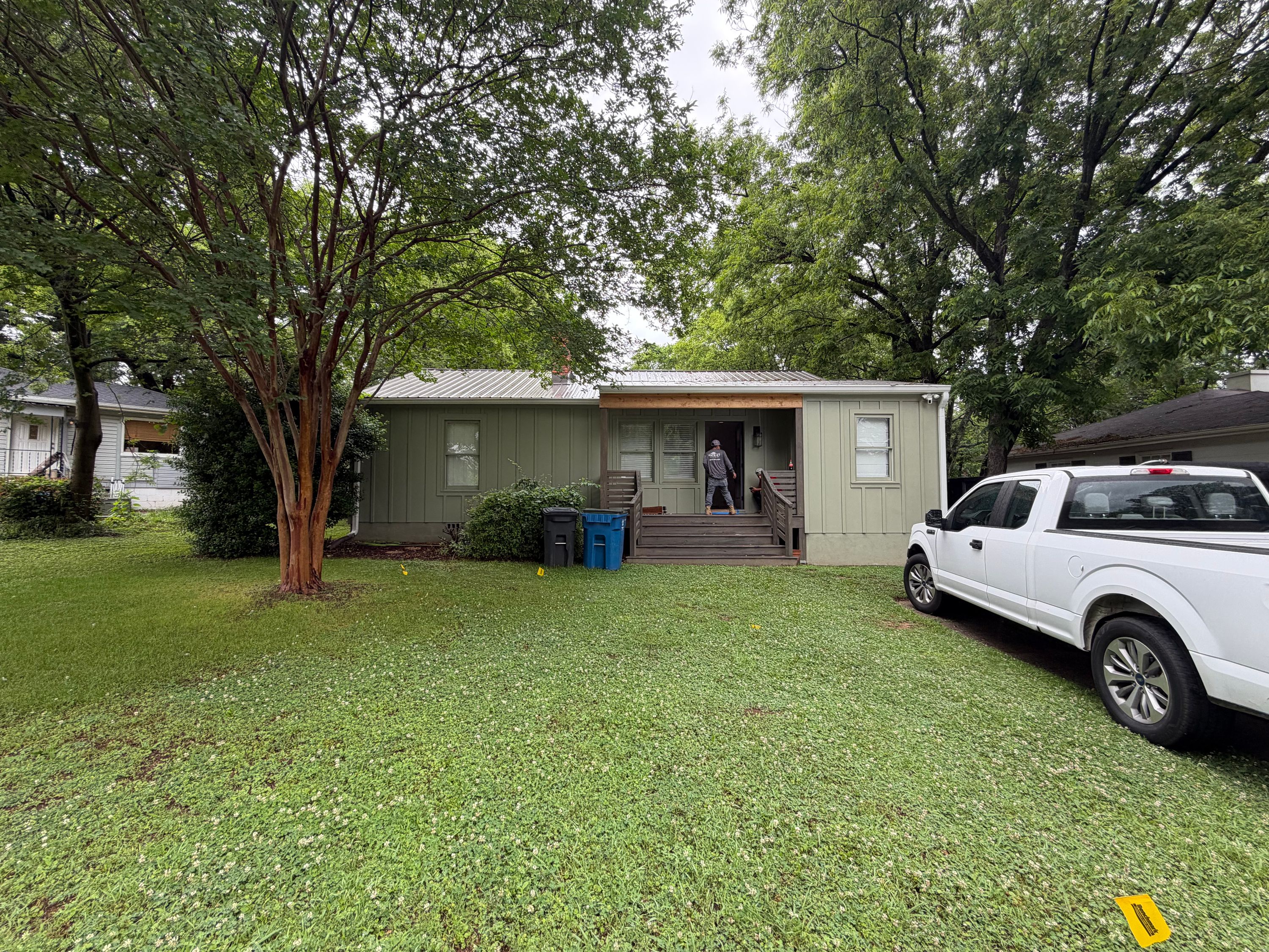 A house with a new metal roof and siding in West Homewood with a pickup truck parked in the yard.