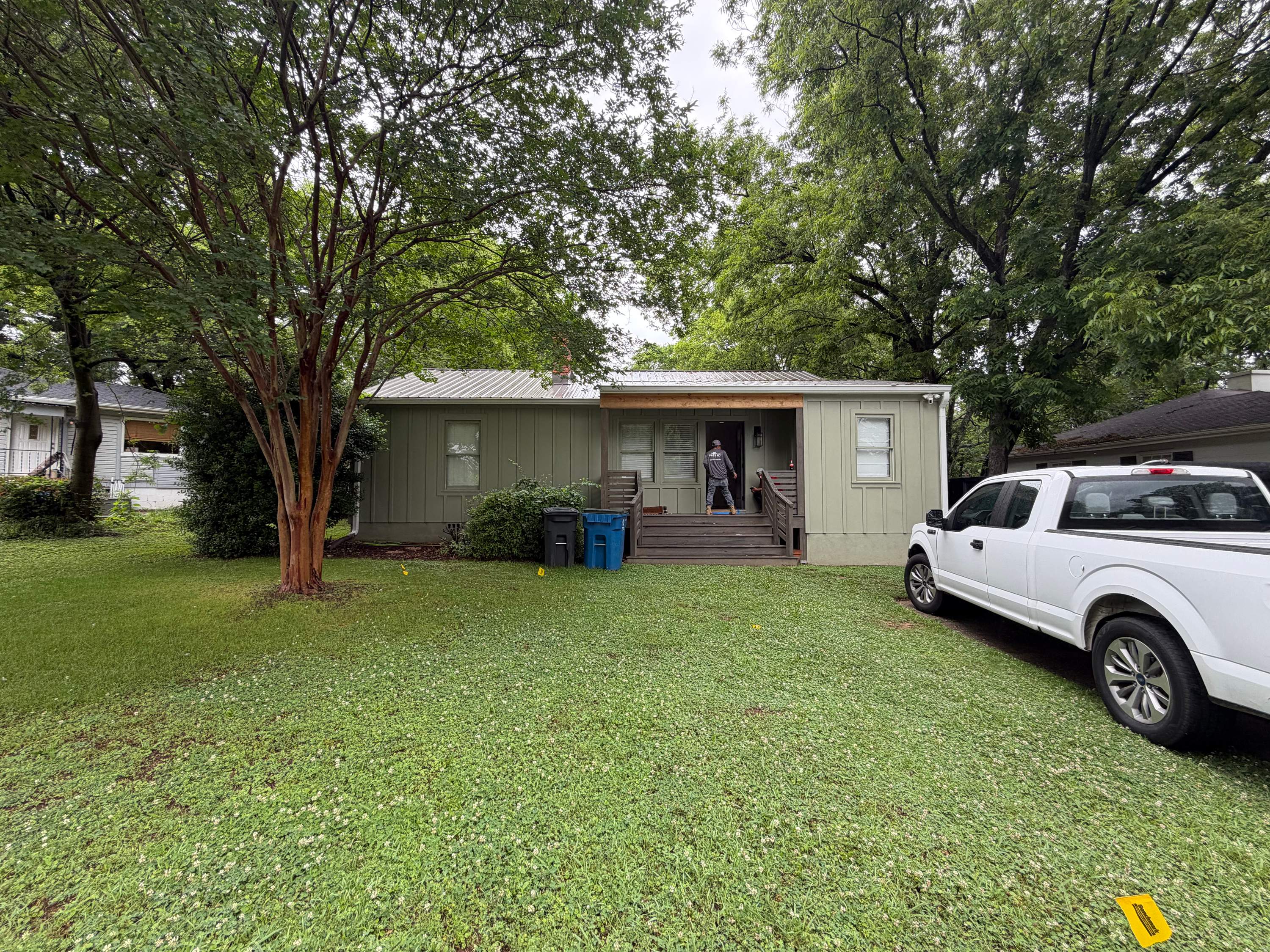 A house with a new metal roof and siding in West Homewood with a pickup truck parked in the yard.