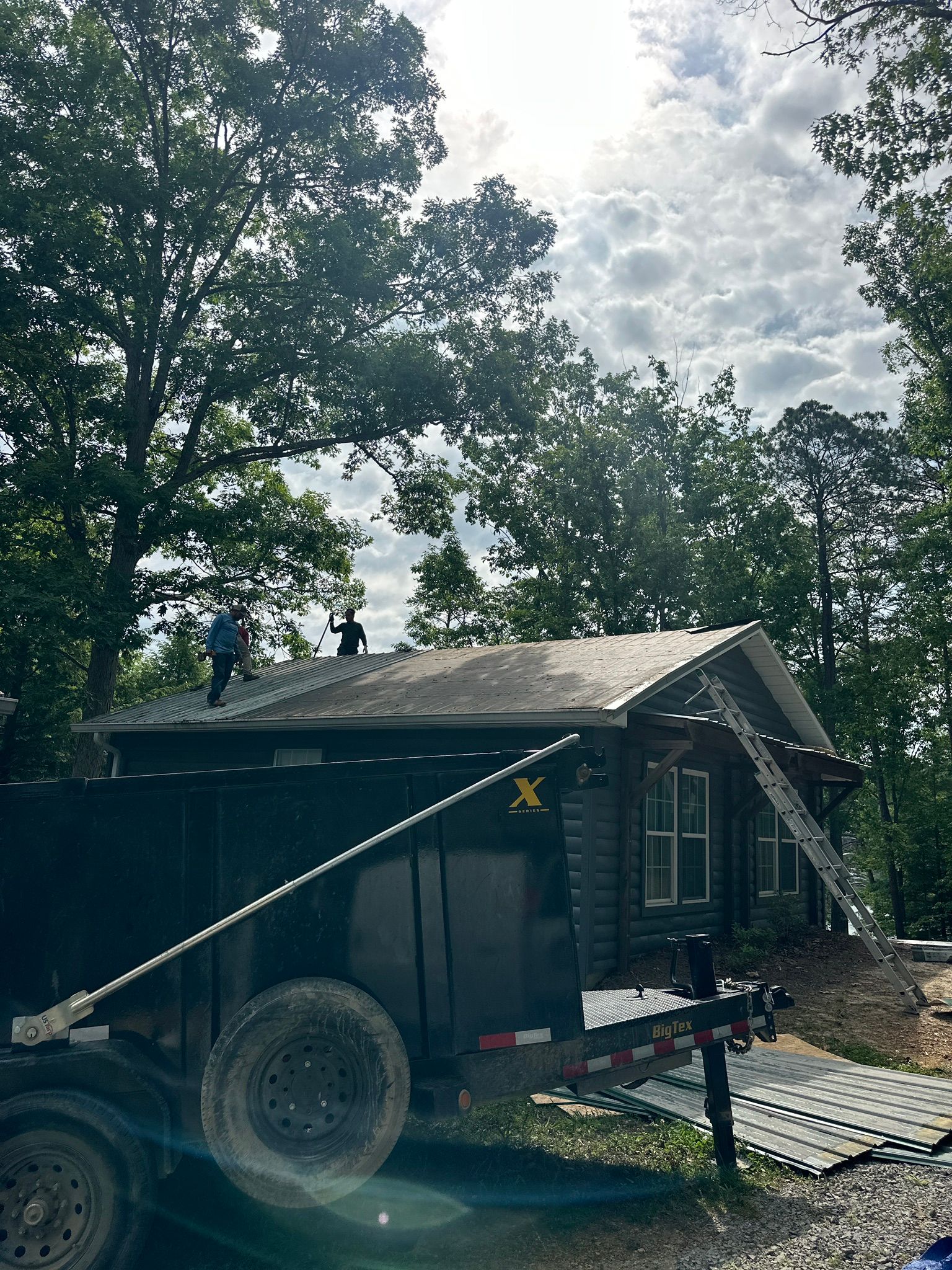 Workers perform a metal roof replacement on a cabin near Smith Lake in Jasper.