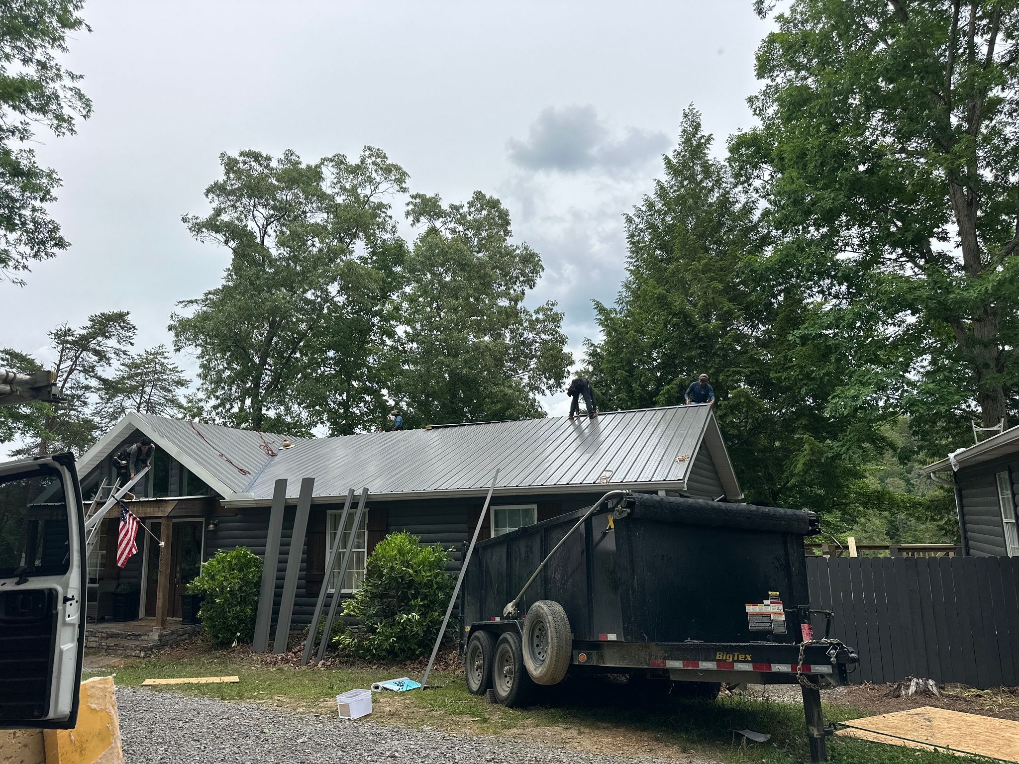 Workers install a new silver metal roof on a log home near Smith Lake in Jasper.
