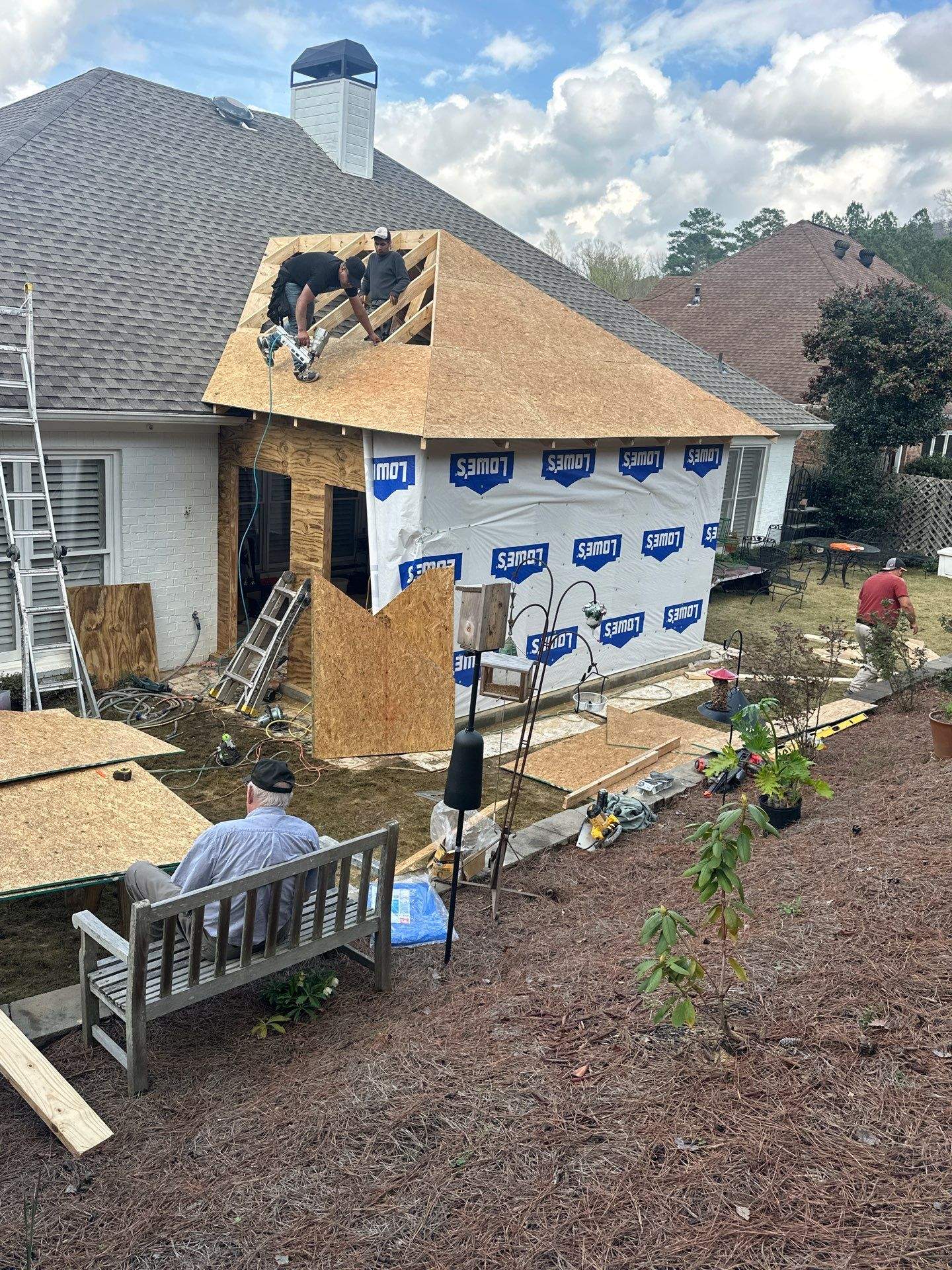 Roofers installing new plywood decking on a home addition during a roof replacement project in Hoover, Alabama.