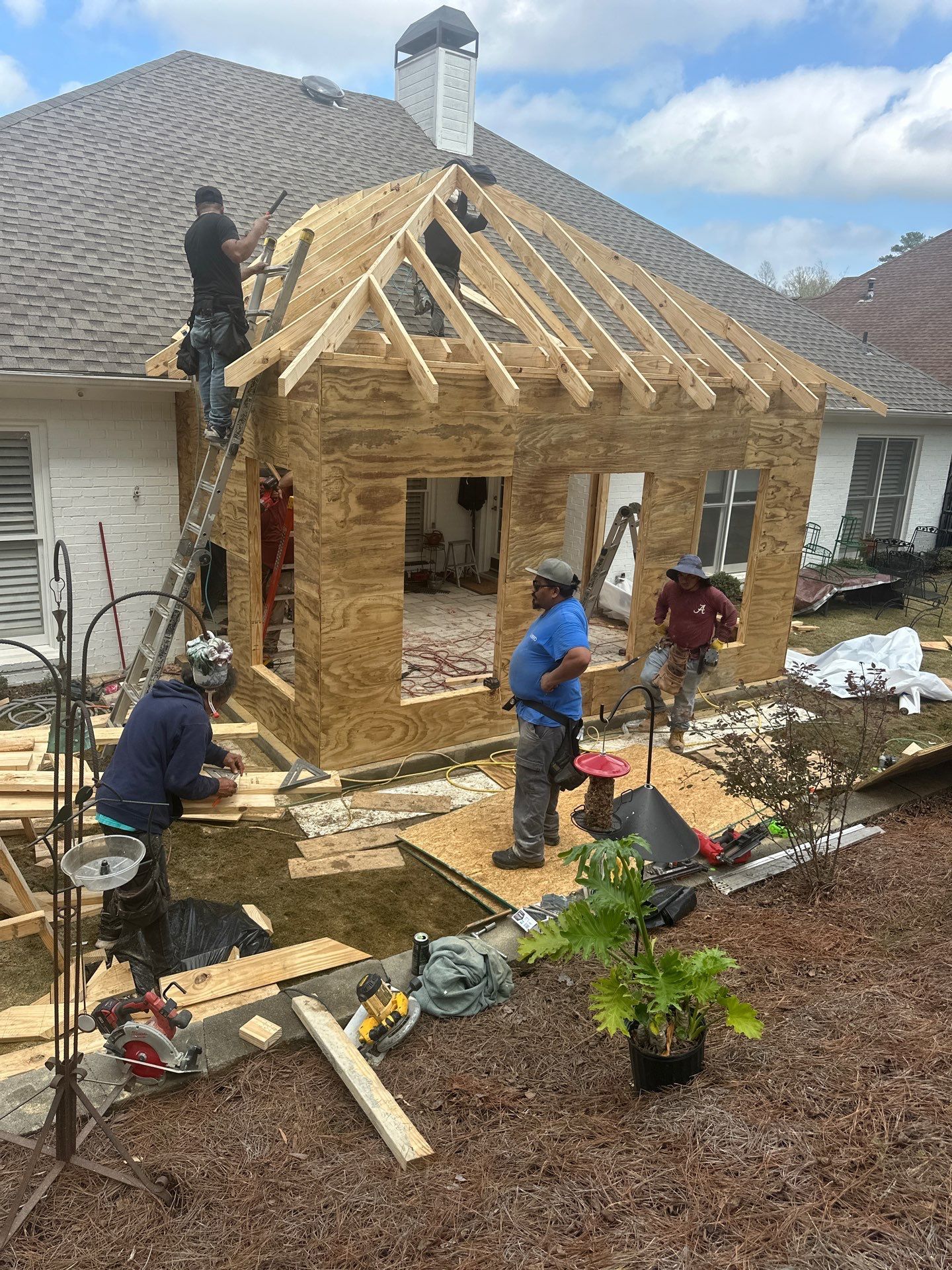 Roofing contractors framing a new roof for a home addition in the Greystone community of Hoover.