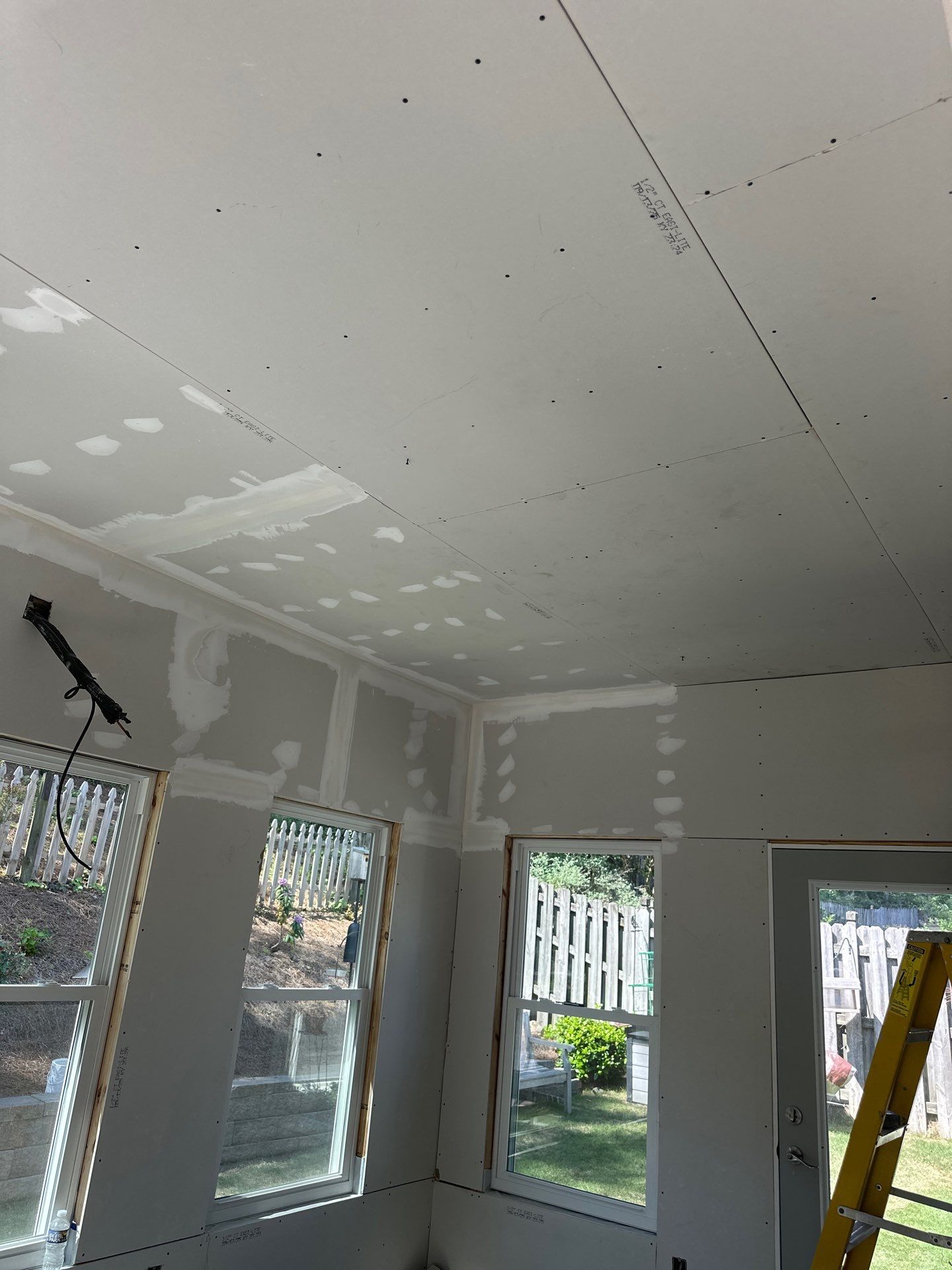 Newly installed drywall panels with taped joints in a Greystone residential renovation project.