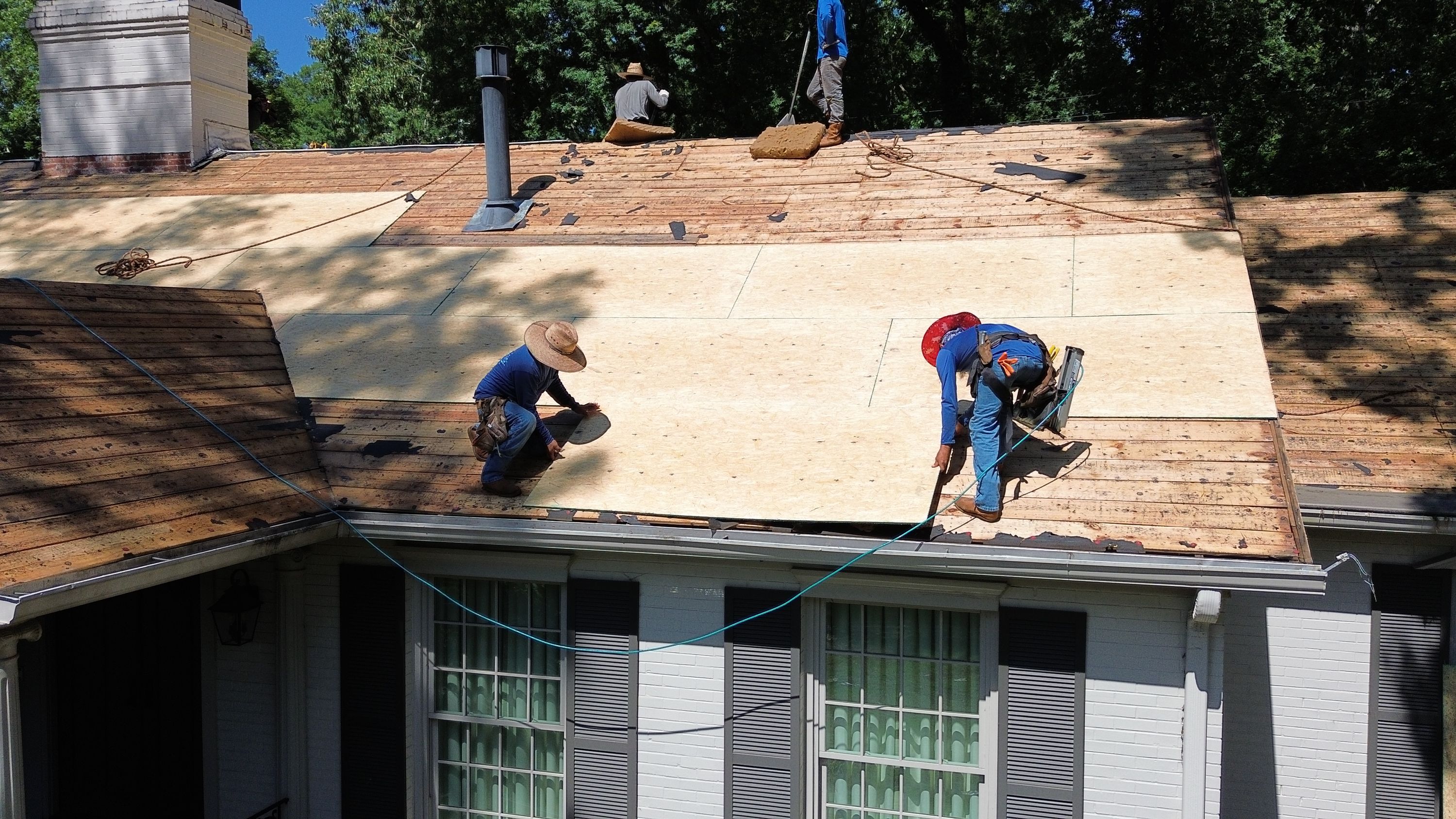 Installing new plywood decking during a residential roof replacement in Mountain Brook.