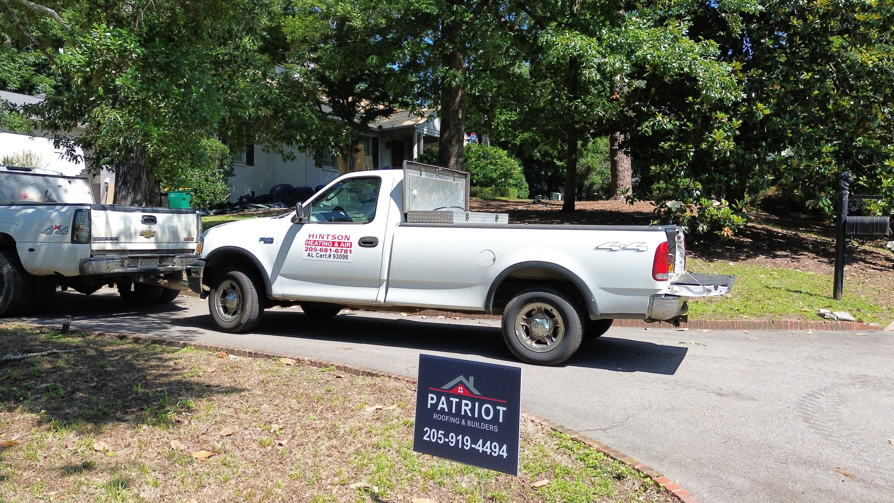 Work vehicles parked during a residential roof replacement in Mountain Brook.