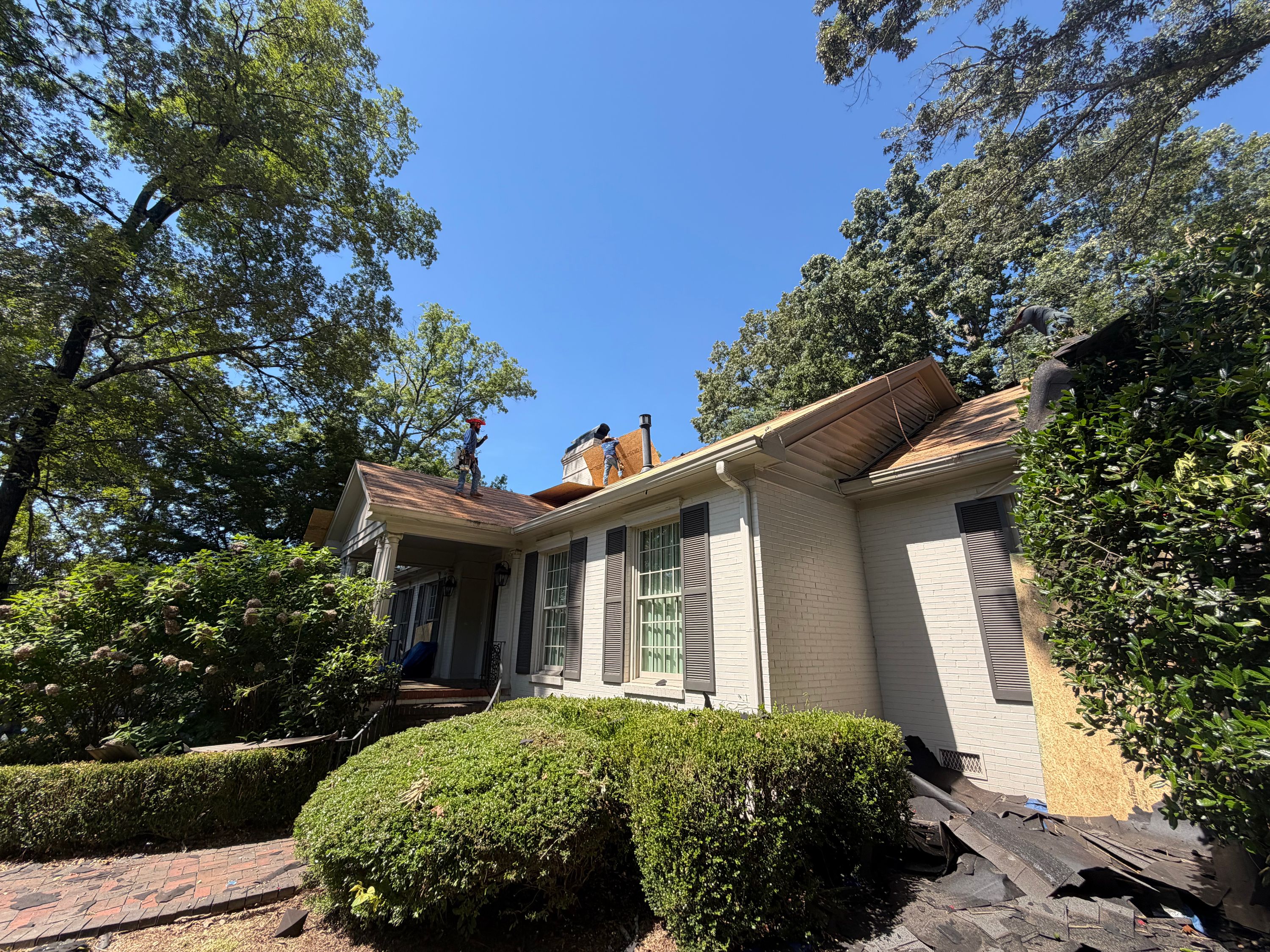 Roof replacement underway on a residential home in Mountain Brook with newly installed plywood decking.