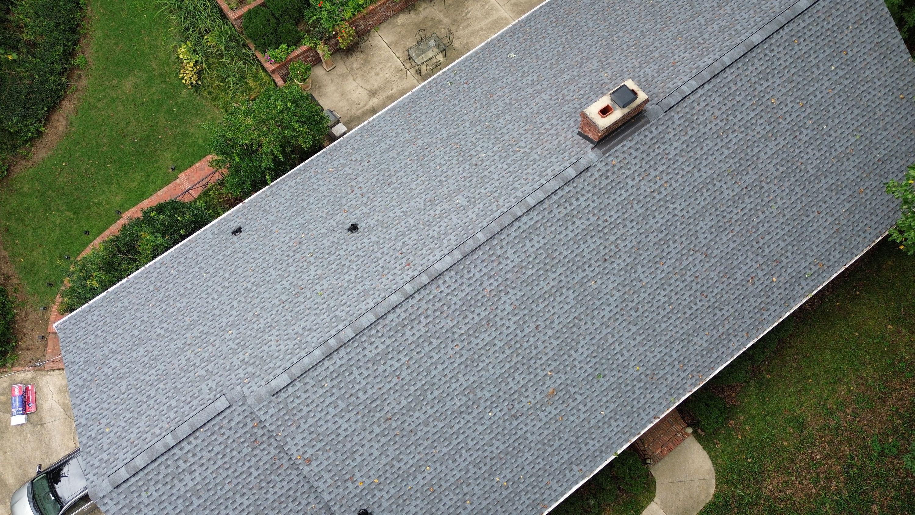 Newly laid architectural shingles and a clean ridge cap run above a patio area in Mountain Brook.