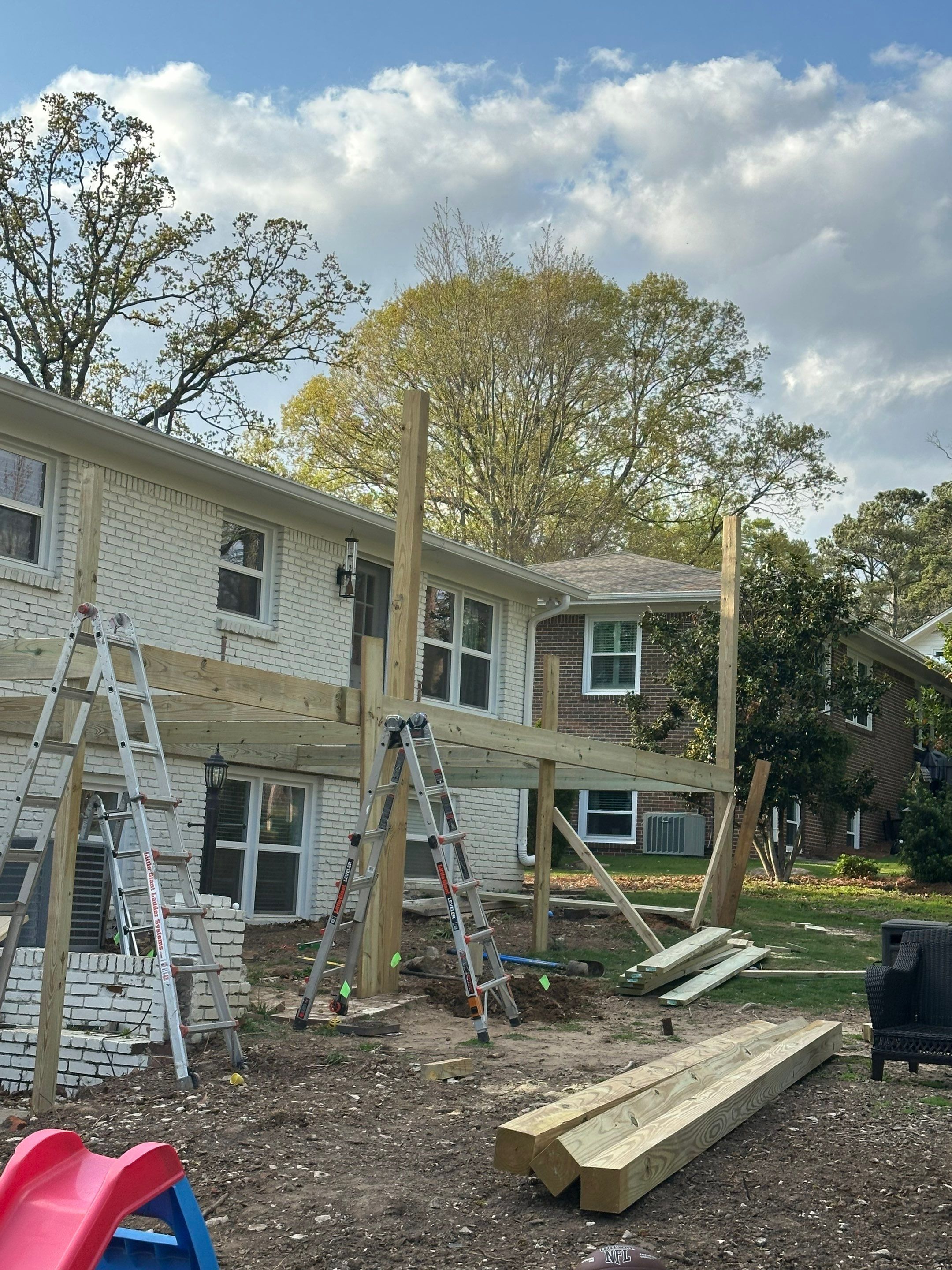 Early framing and structural wood support installation for a large custom deck project in Vestavia North.