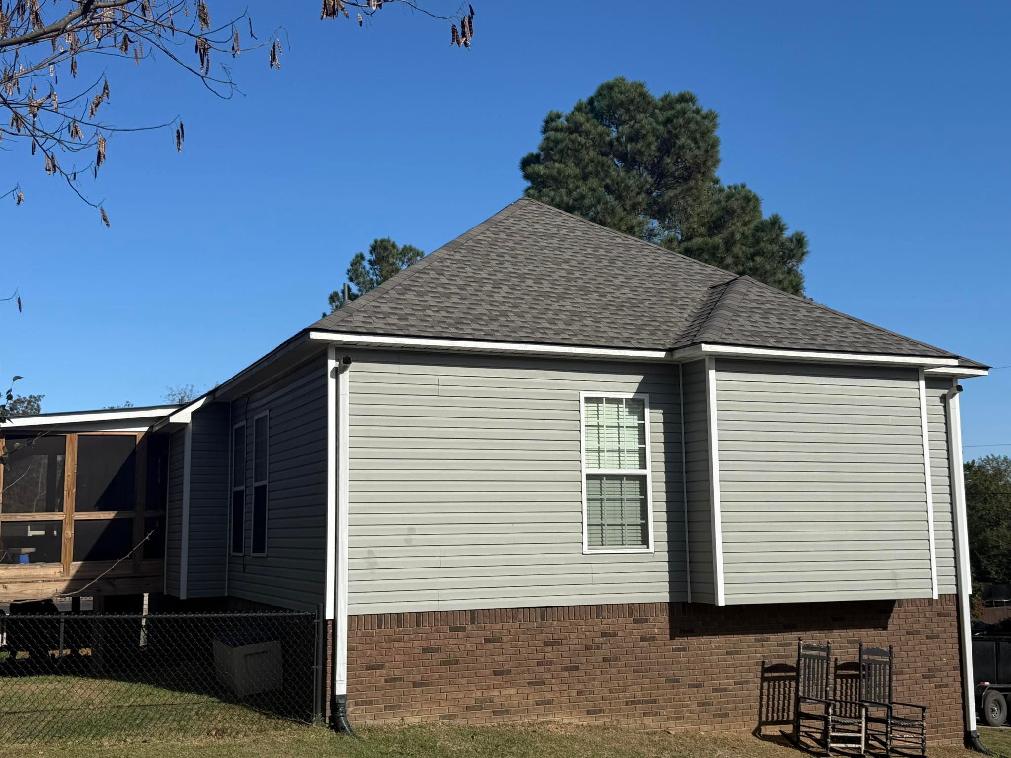 Side profile of a completed roof replacement on a gray-sided home in Trussville, Alabama.