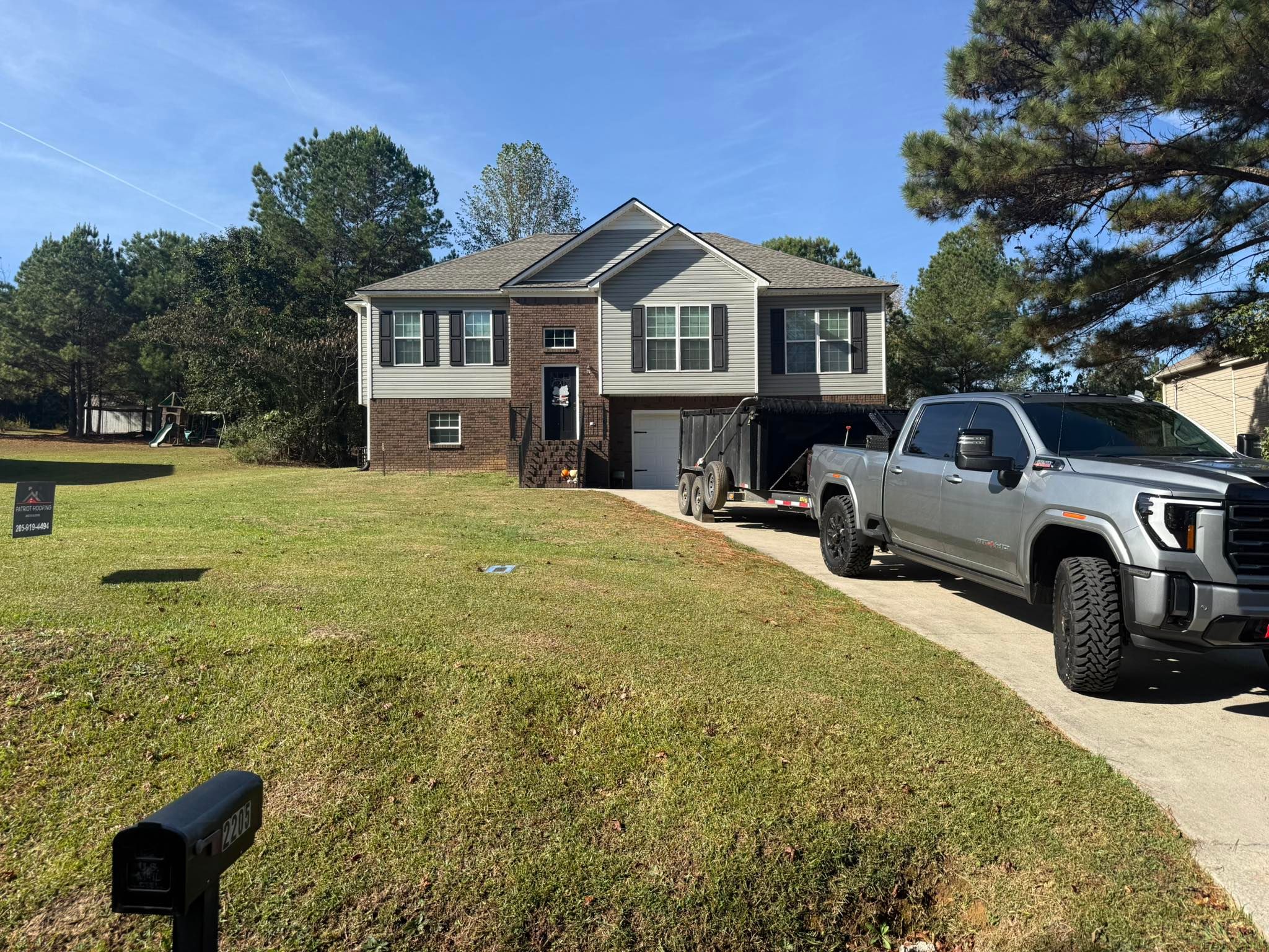 Patriot Roofing & Builders service vehicle at a residential roof replacement project in Longmeadow, Trussville.