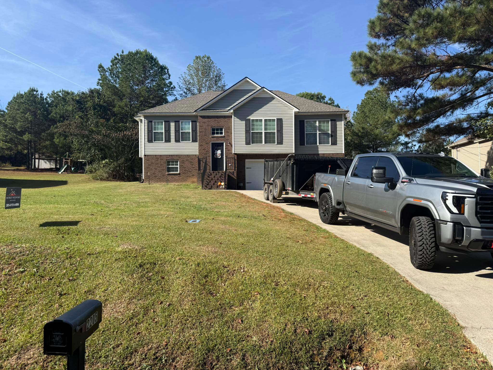 Patriot Roofing & Builders service vehicle at a residential roof replacement project in Longmeadow, Trussville.