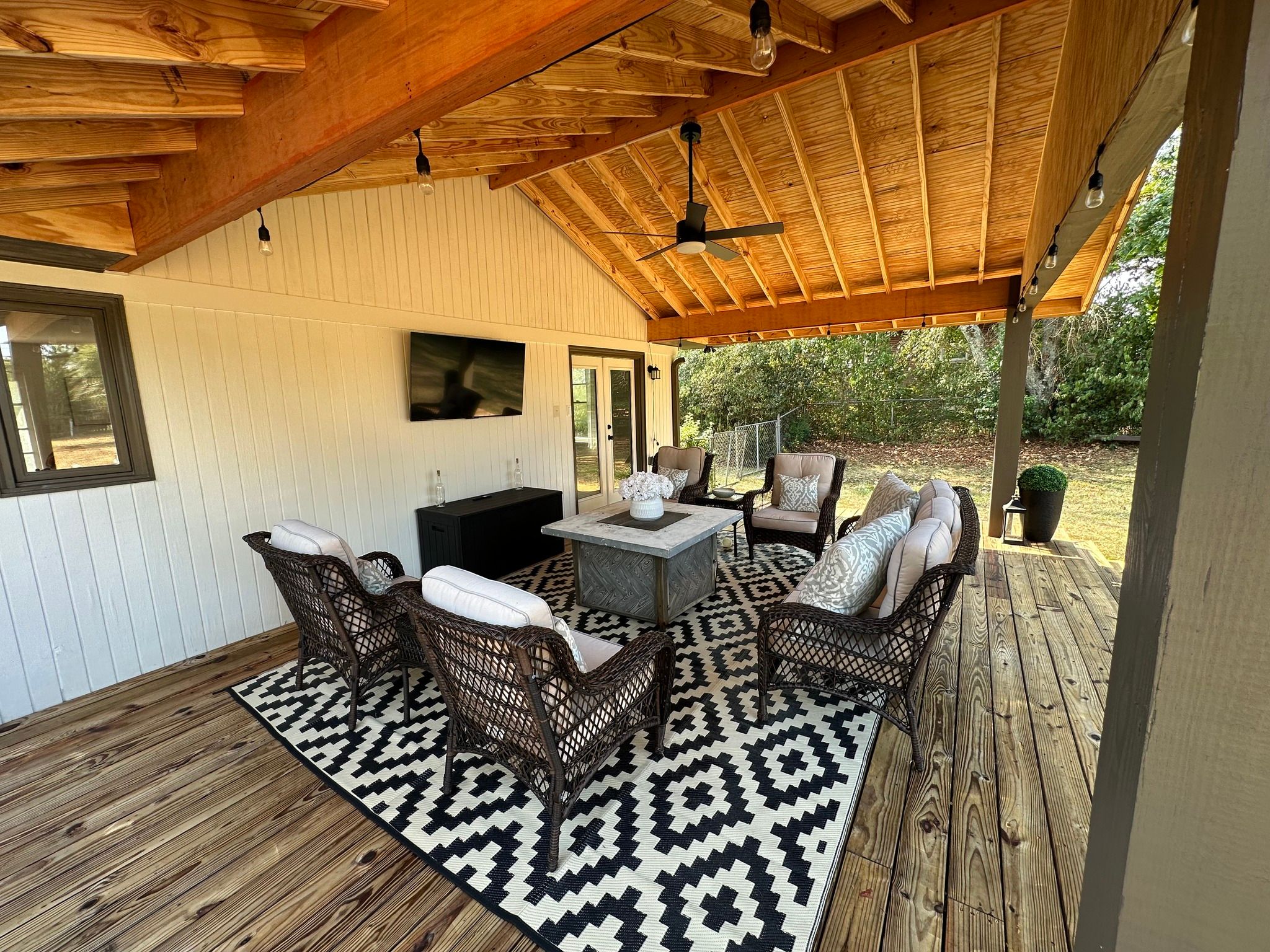Interior view of a custom deck addition in Hoover, AL, showcasing high-quality wood rafter ceilings, string lighting, and a modern ceiling fan.