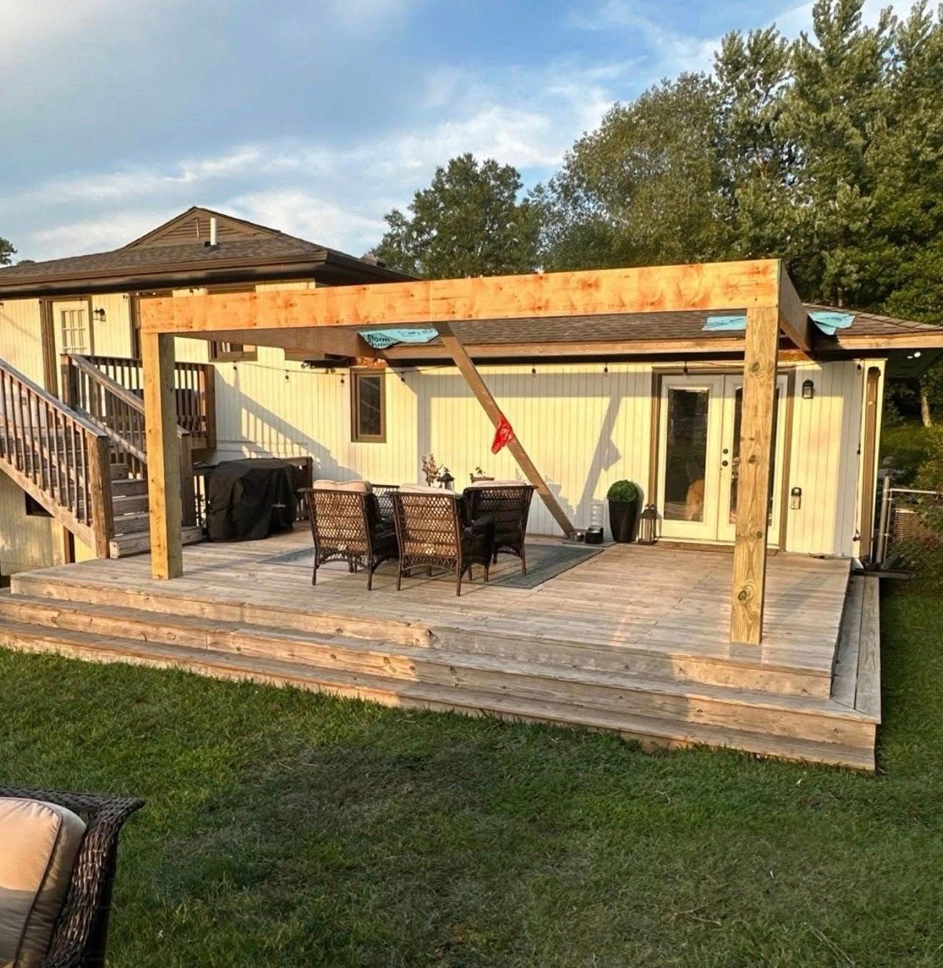 The framing stage of a custom deck build in Bluff Park, showing heavy timber support beams being installed for the new roof structure.