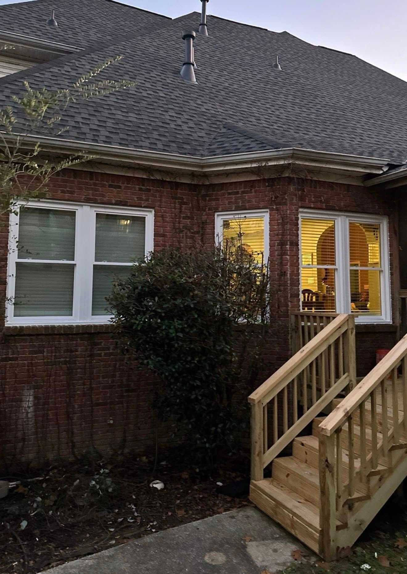 Back view of a brick house in Hoover showcasing newly installed energy-efficient windows and new wooden stairs.